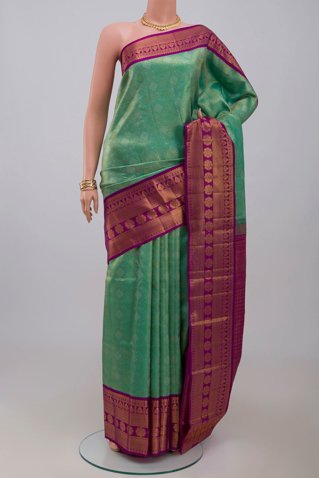 Green Kanchipuram Silk Saree with Zari Brocade on the body and Zari Border.  displayed on a mannequin