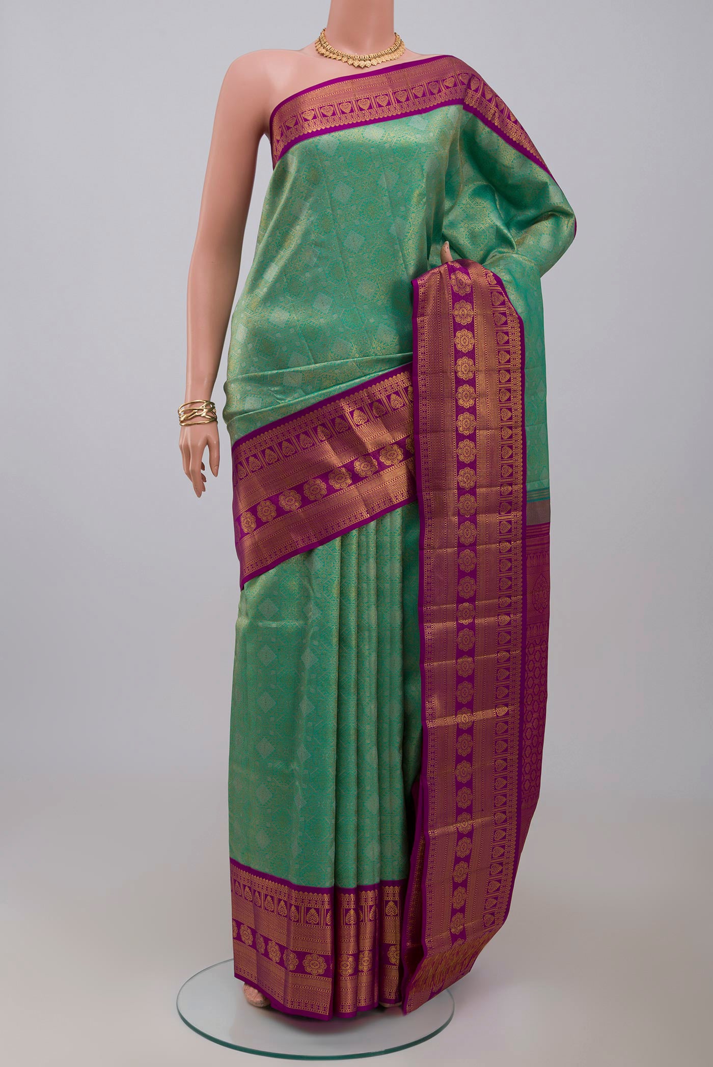 Green Kanchipuram Silk Saree with Zari Brocade on the body and Zari Border.  displayed on a mannequin