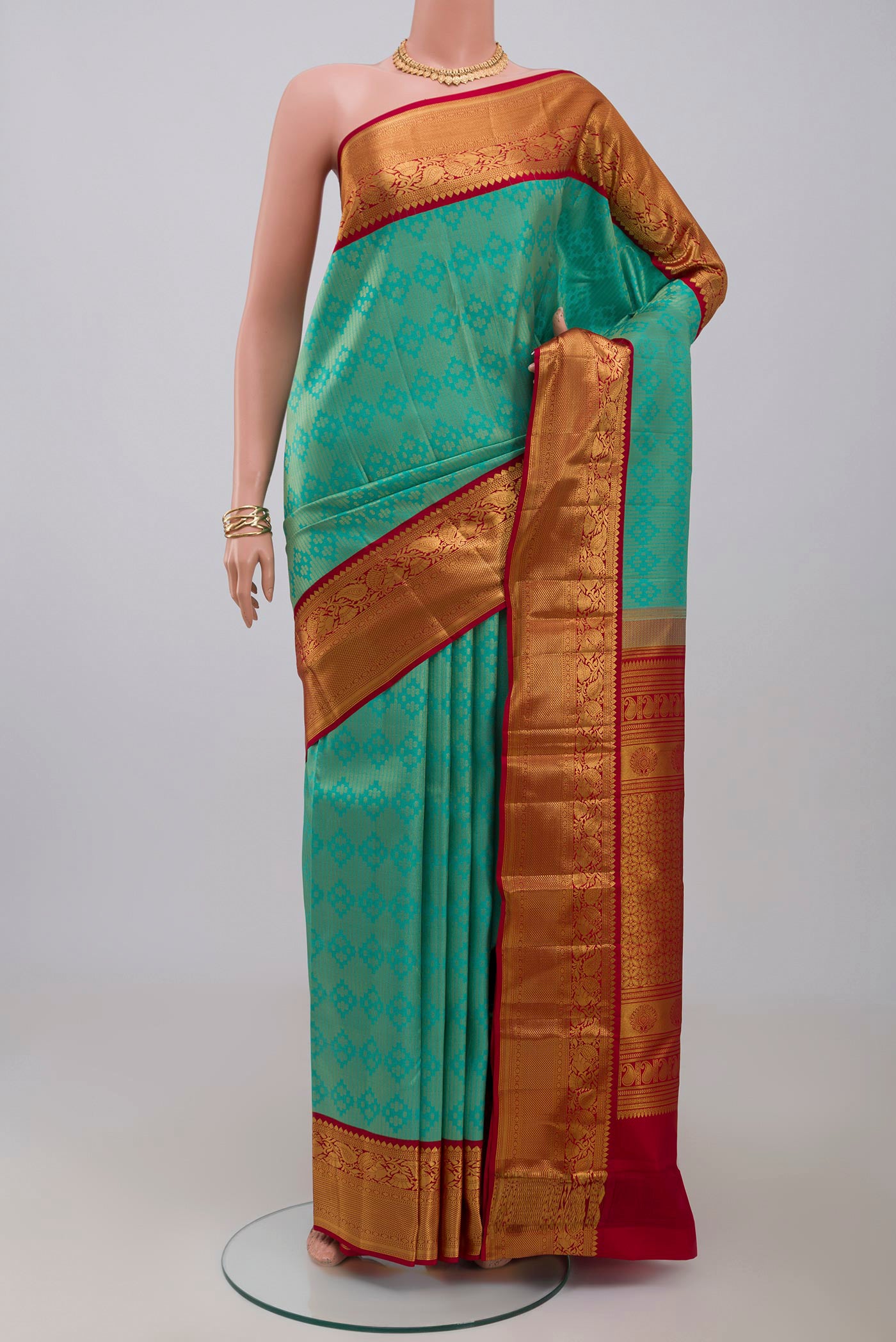 Green Kanchipuram Silk Saree with Zari Brocade on the body and Zari Border.  displayed on a mannequin