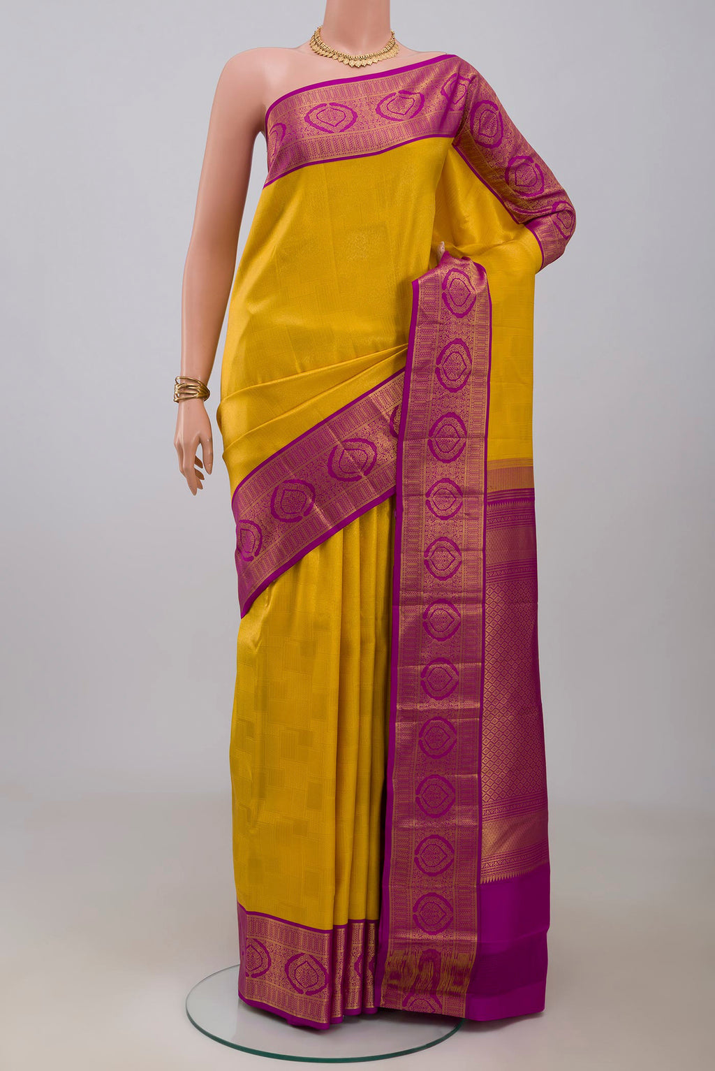 Yellow Kanchipuram Silk Saree with Zari Brocade on the body and Zari Border.  displayed on a mannequin