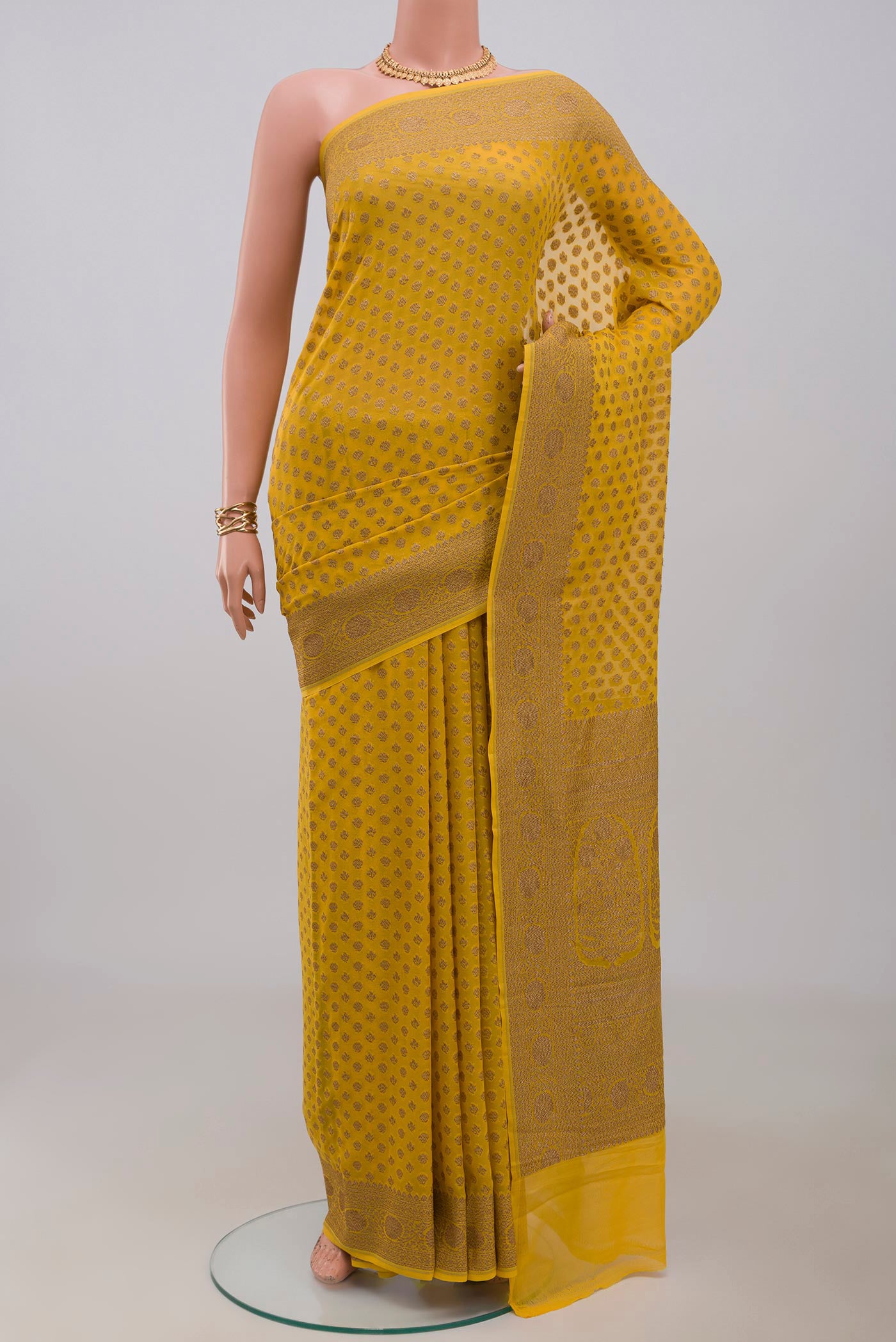 Yellow Georgette Saree with Fancy on the body and Fancy Border.  displayed on a mannequin