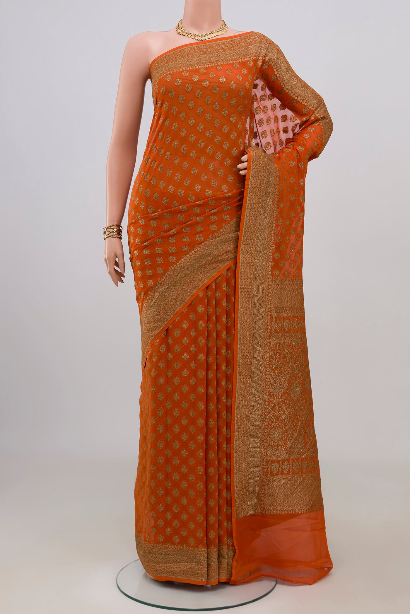 Orange Banarasi Georgette Saree with Zari Butta on the body and Zari Border.  displayed on a mannequin