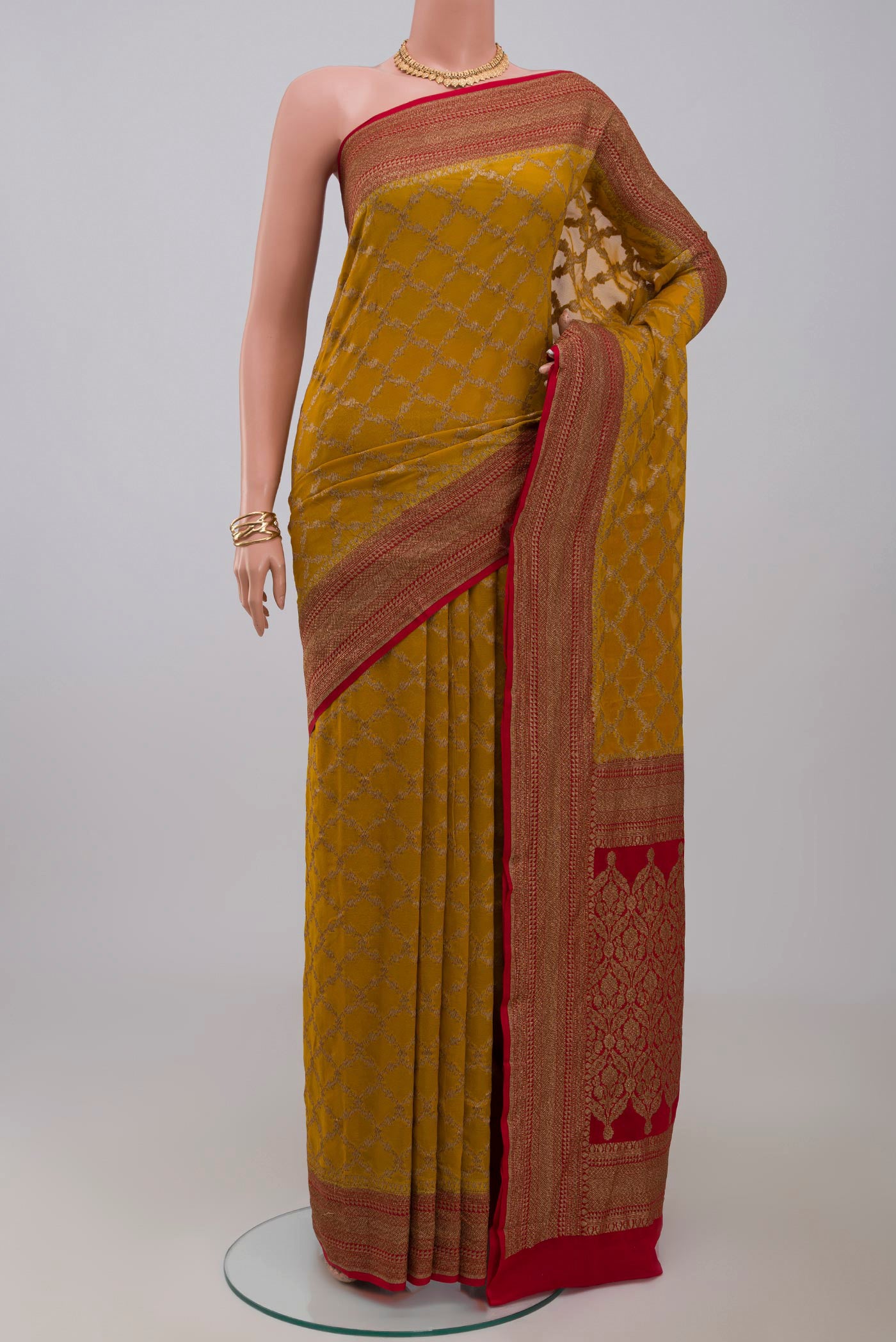 Yellow Georgette Saree with Fancy on the body and Zari Border.  displayed on a mannequin