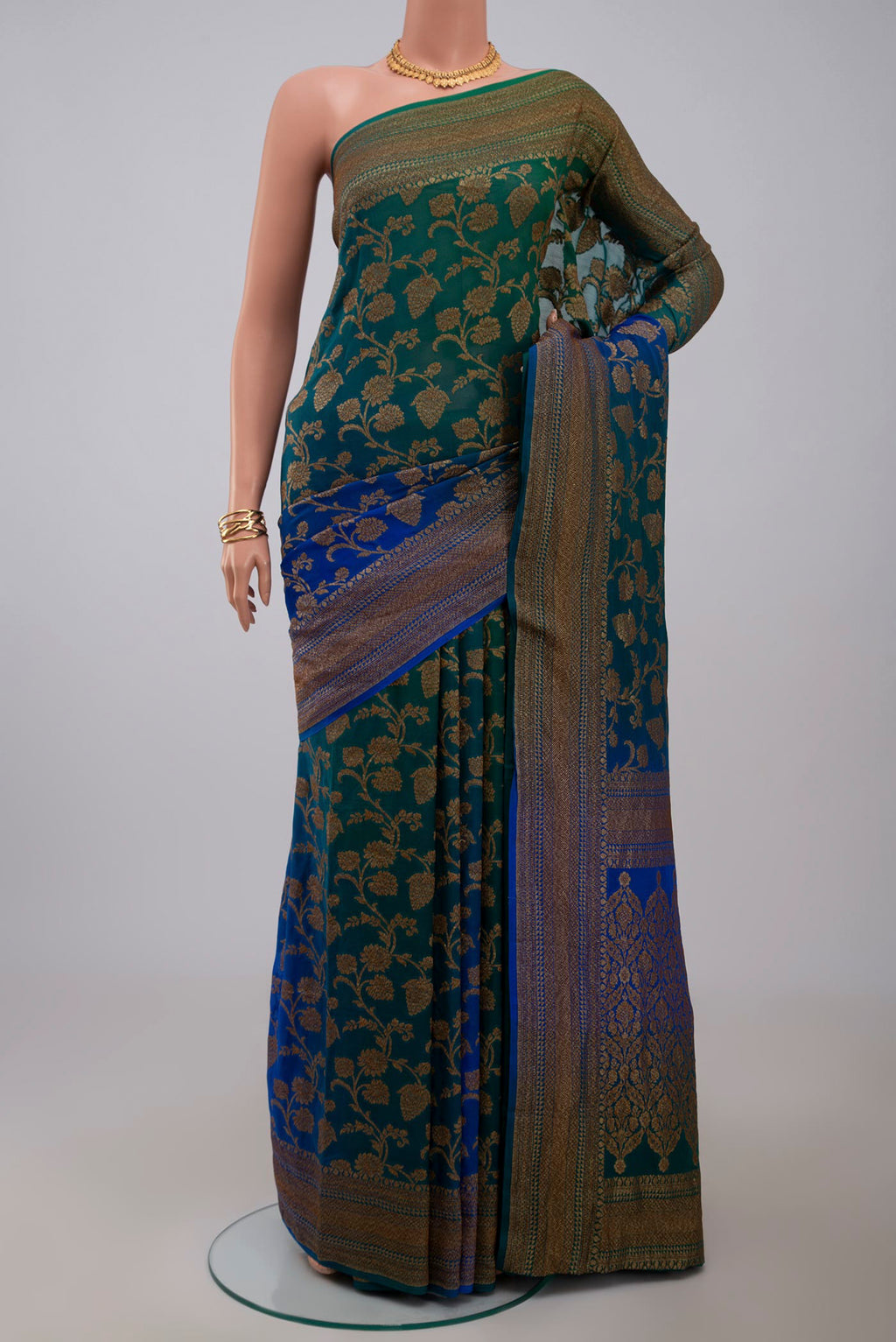 Green Georgette Saree with Fancy on the body and Zari Border.  displayed on a mannequin