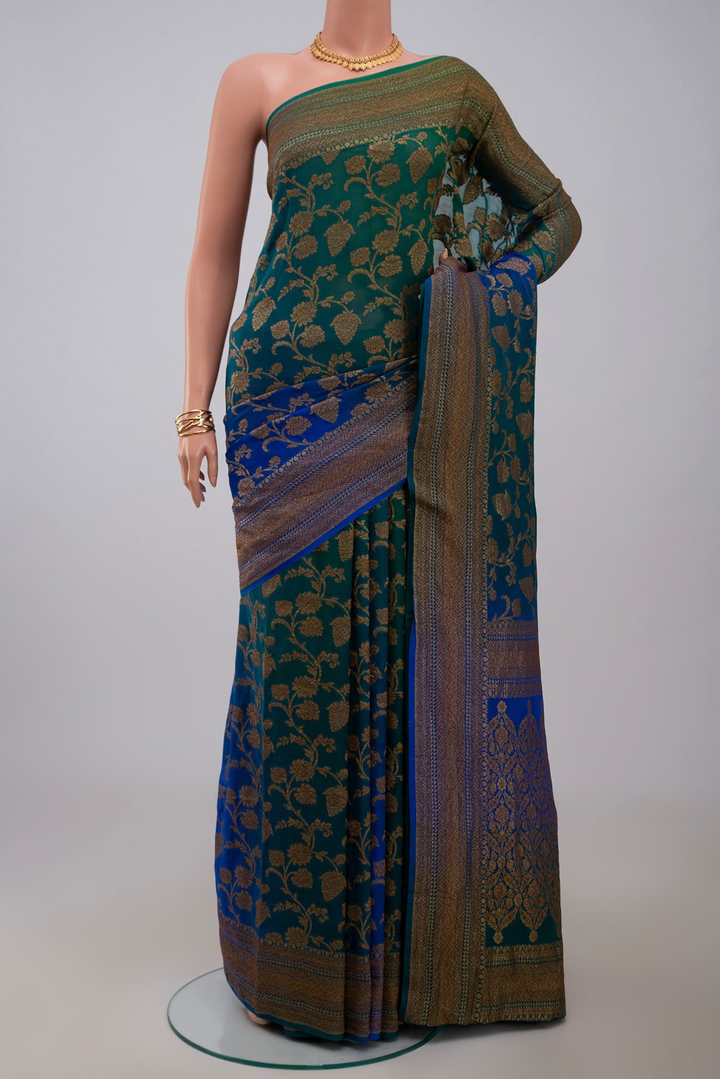 Green Georgette Saree with Fancy on the body and Zari Border.  displayed on a mannequin