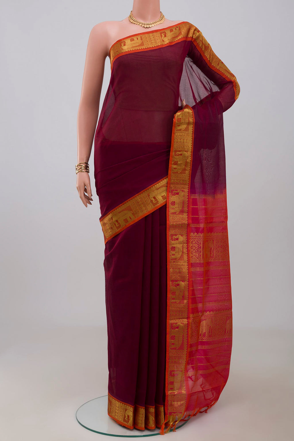 Maroon Silk Cotton Saree with Plain Body and Zari Border.  displayed on a mannequin
