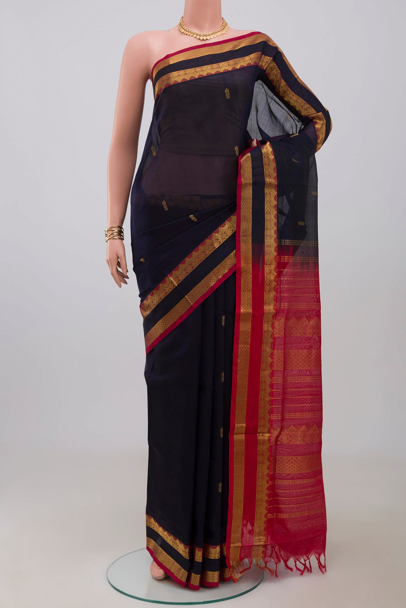 Navy Blue Silk Cotton Saree with Zari Butta on the body and Zari Border.  displayed on a mannequin