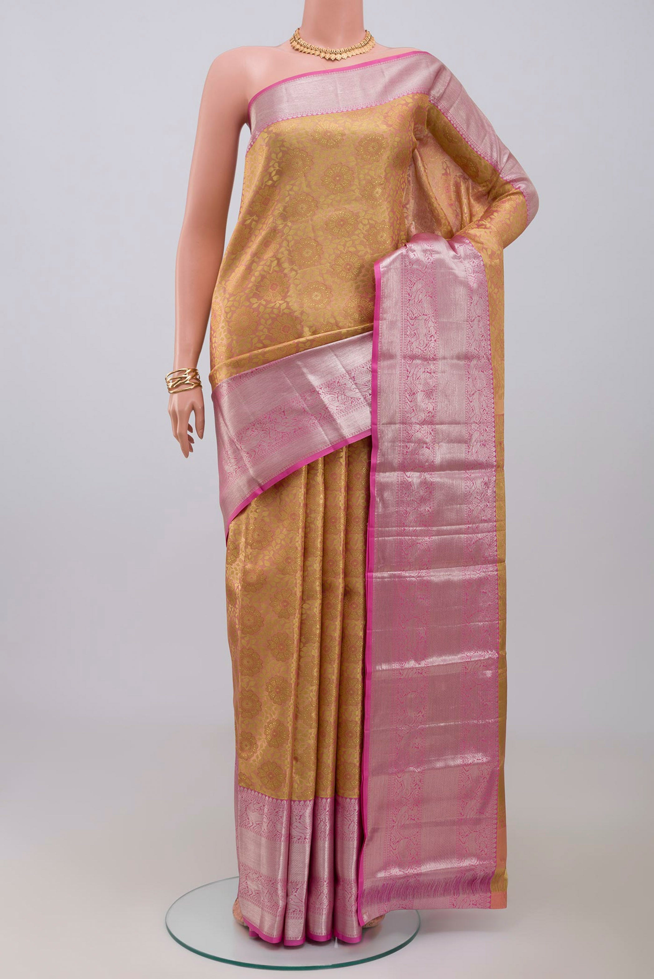 Golden Peach Kanchipuram Silk Saree with Zari Brocade on the body and Zari Border.  displayed on a mannequin