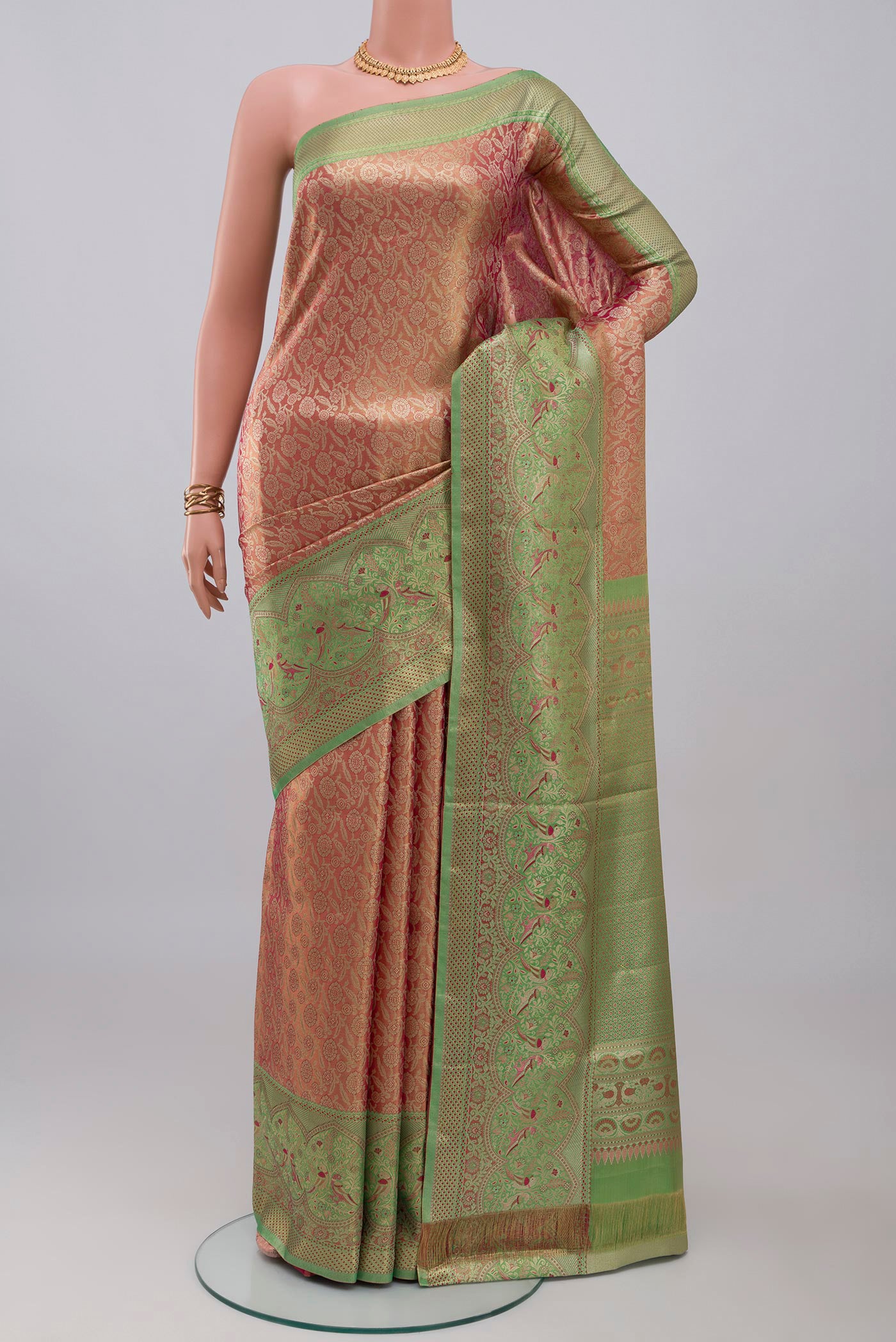 Peach Kanchipuram Tissue Silk Saree with Zari Brocade on the body and Fancy Border.  displayed on a mannequin