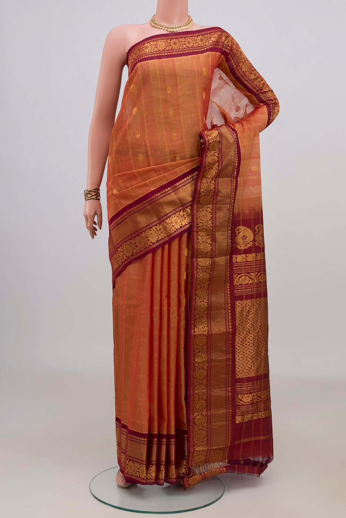 Peach Gadwal Cotton Saree with Checked design on the body and Zari Border.  displayed on a mannequin