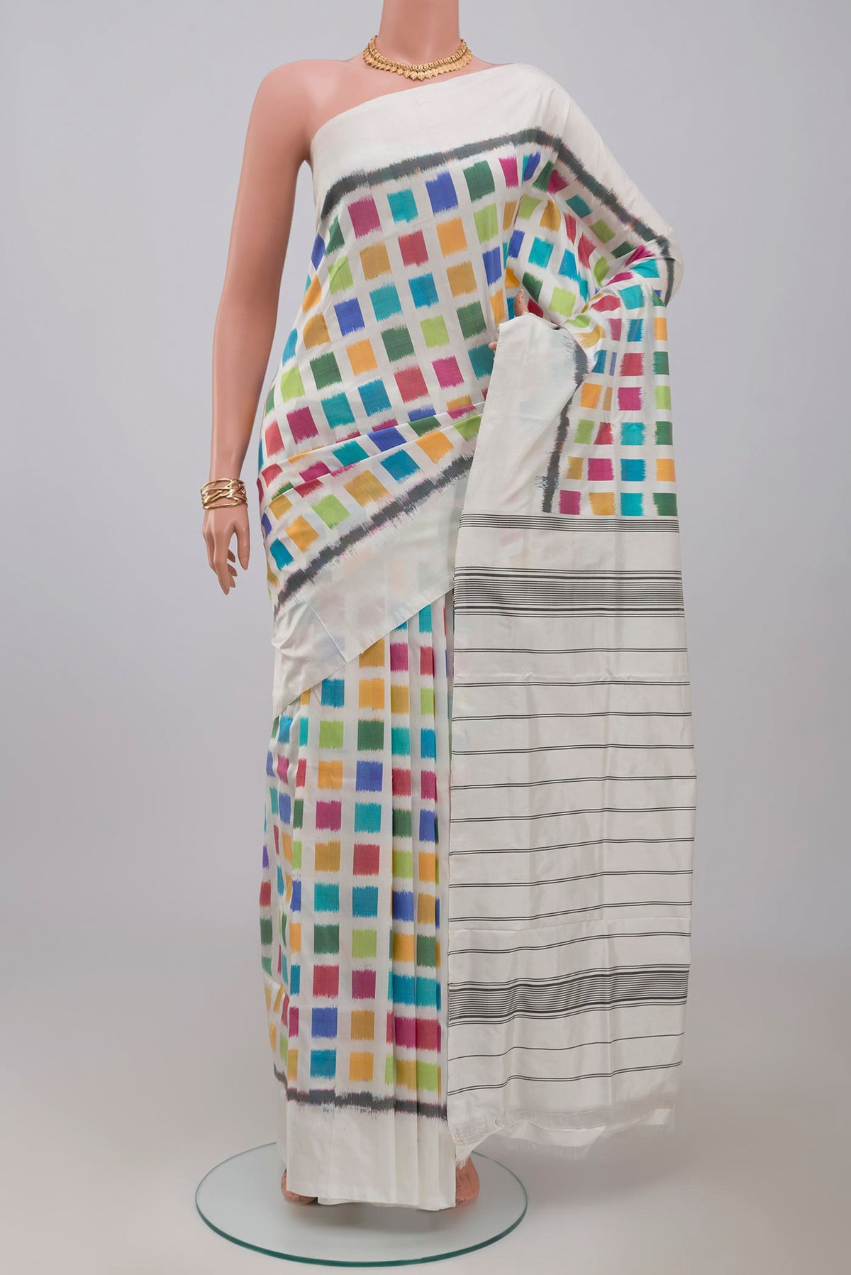 White Pochampally Silk Saree with Ikat design on the body and Plain Border.  displayed on a mannequin
