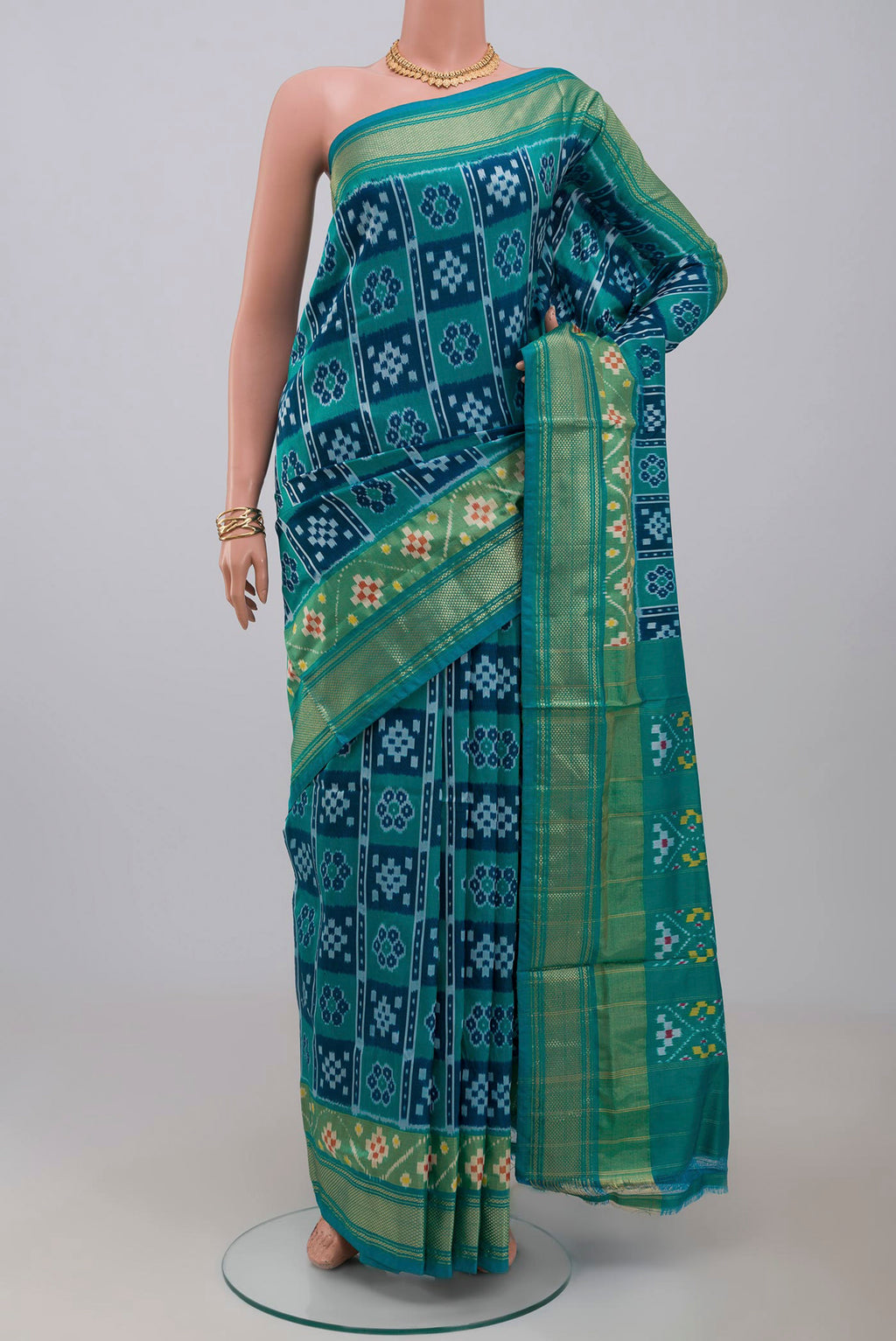 Green Pochampally Silk Saree with Ikat design on the body and Zari Border.  displayed on a mannequin