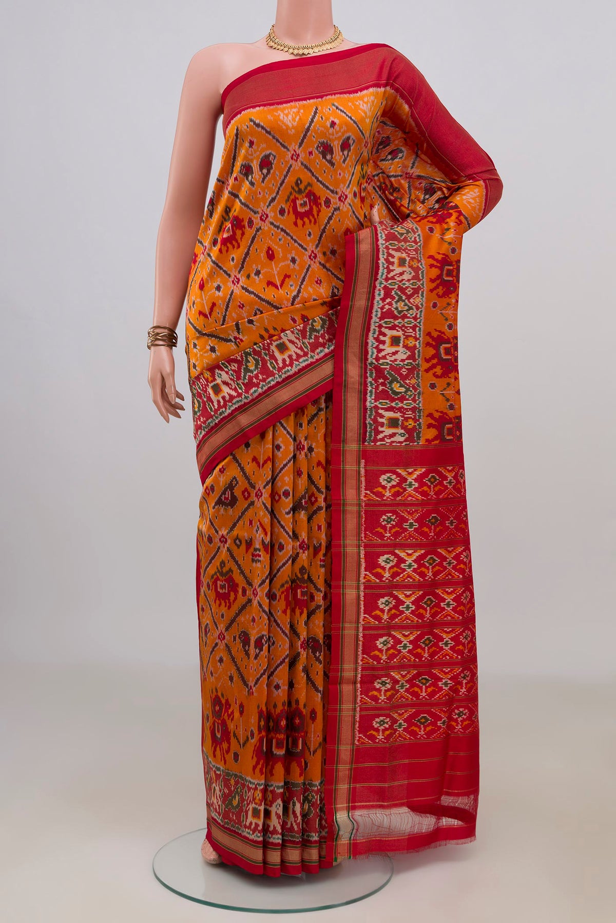 Pure Silk Orange Pochampally Saree with Ikat design on the body and Zari Border.  displayed on a mannequin