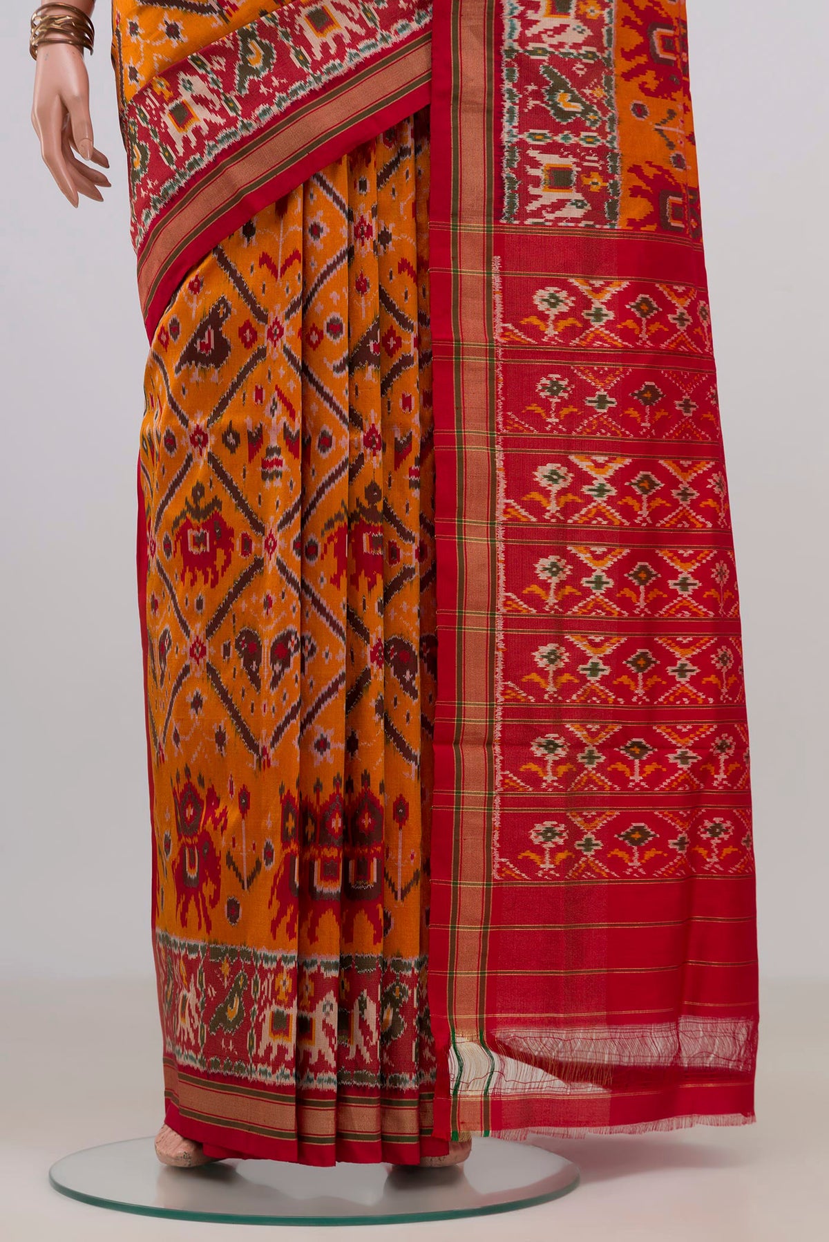 Pleats and pallu of Pure Silk Orange Pochampally Saree with Ikat design on the body and Zari Border. 