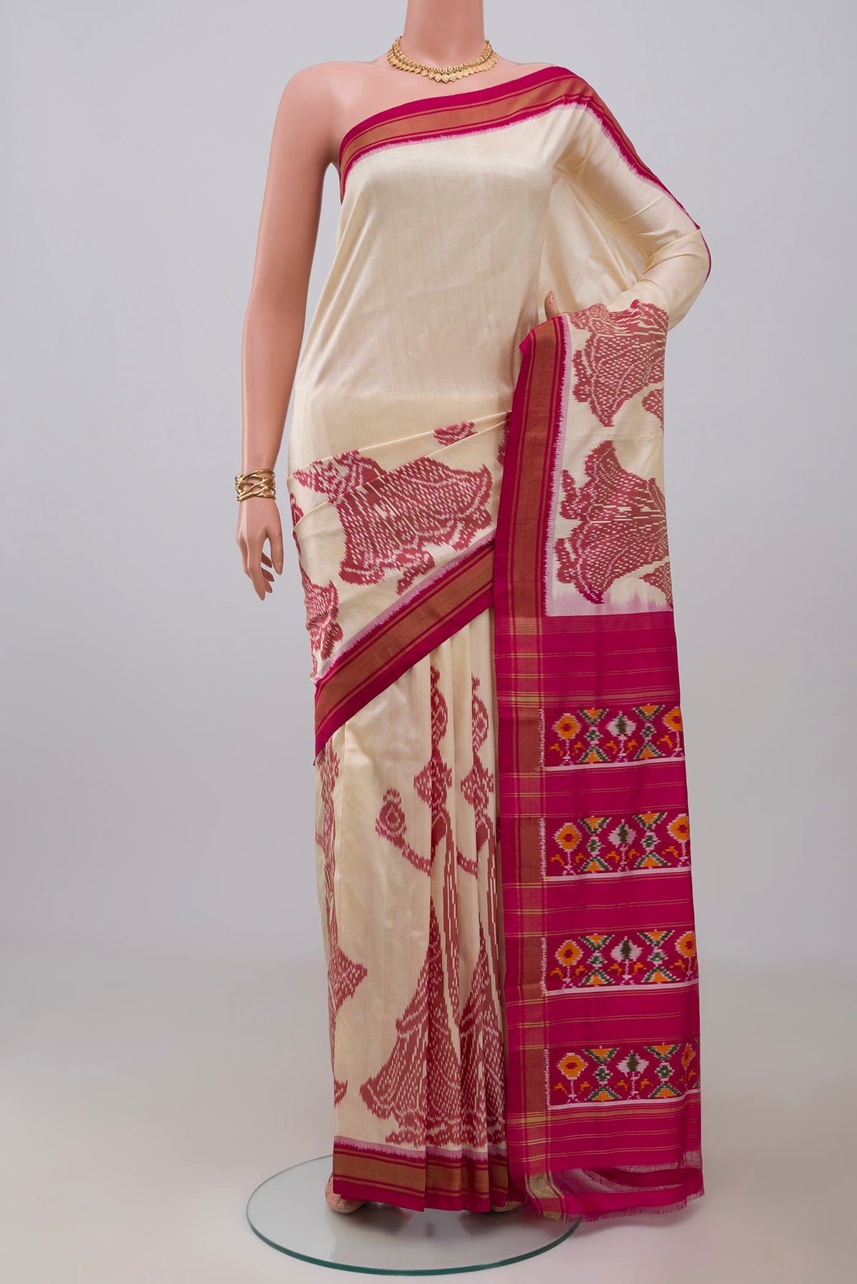 Off White Pochampally Silk Saree with Ikat design on the body and Zari Border.  displayed on a mannequin