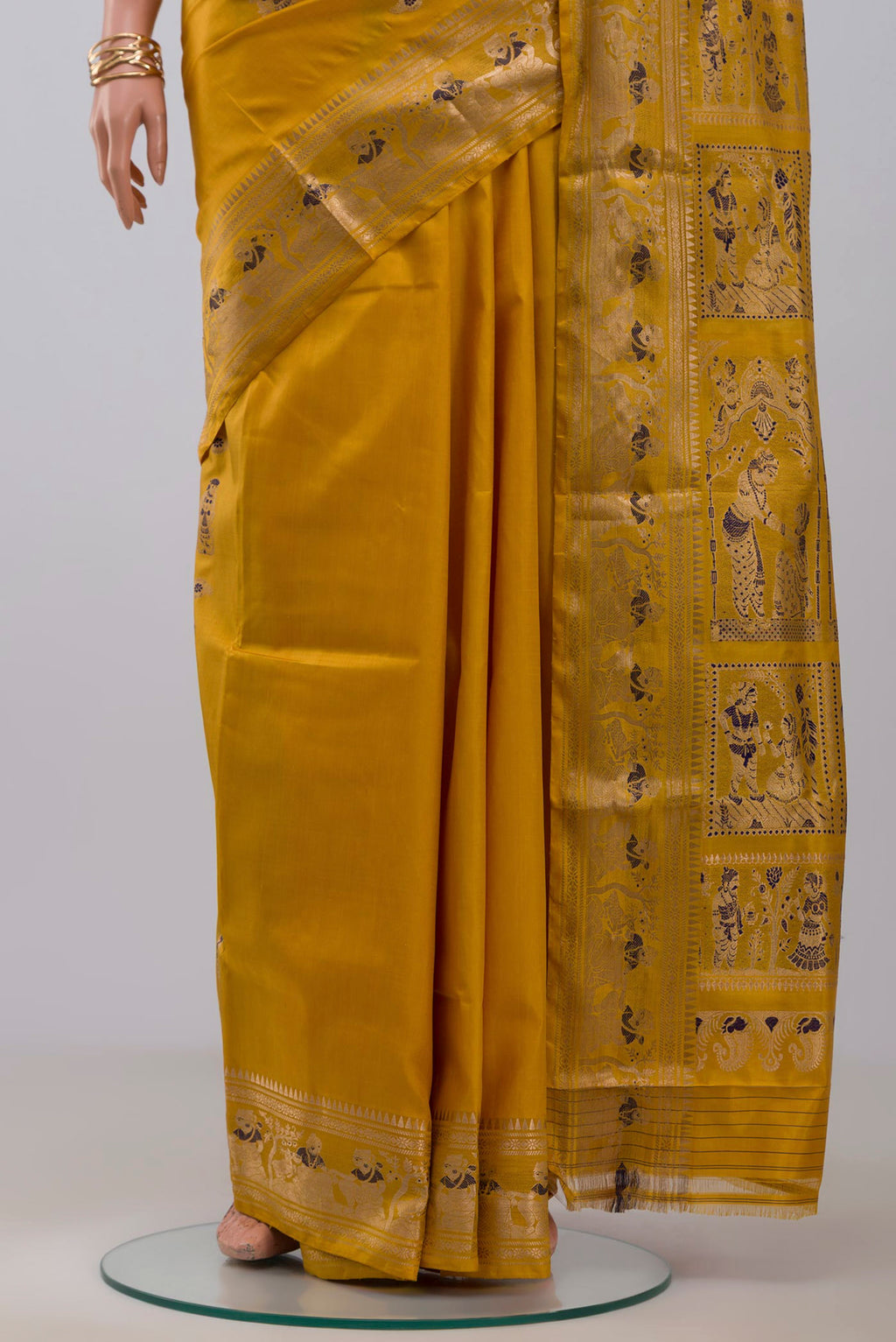 Pleats and pallu of Yellow Baluchari Silk Saree with Zari Butta on the body and Zari Border. 