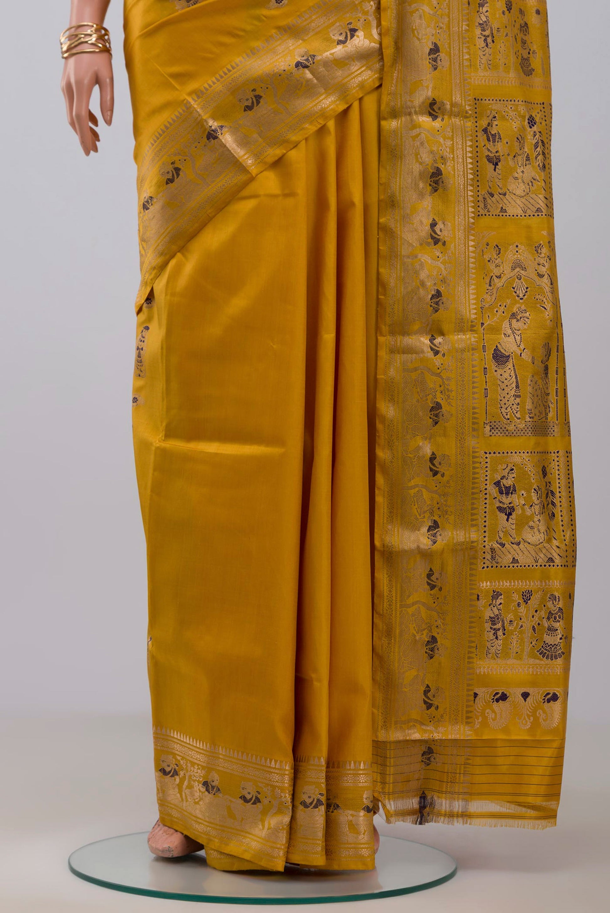 Pleats and pallu of Yellow Baluchari Silk Saree with Zari Butta on the body and Zari Border. 