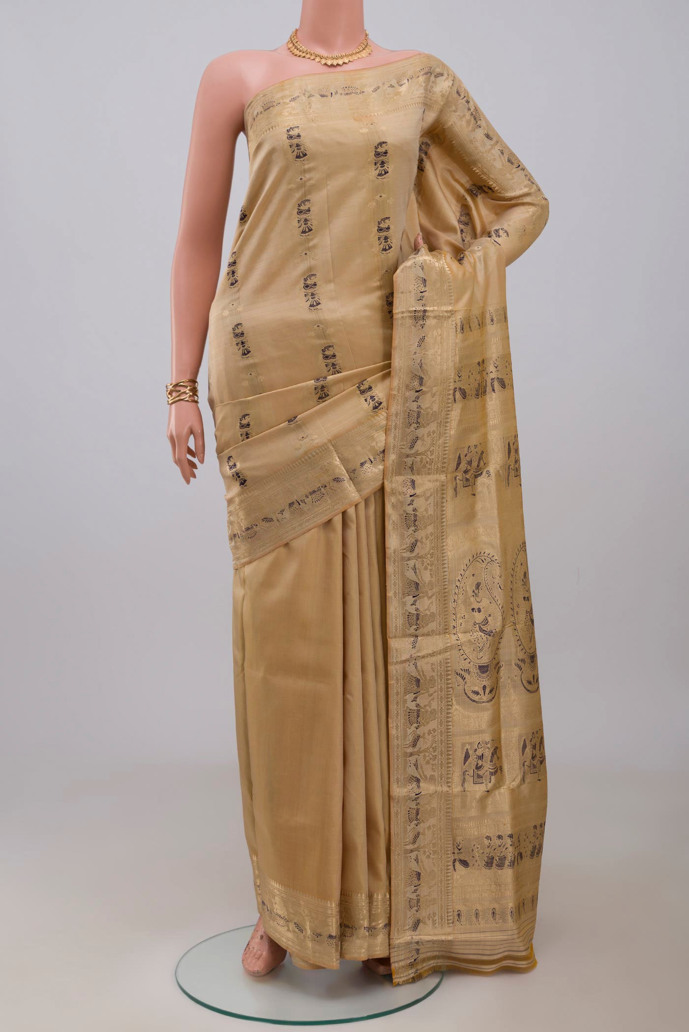 Beige Baluchari Silk Saree with Zari And Thread Butta on the body and Zari Border.  displayed on a mannequin