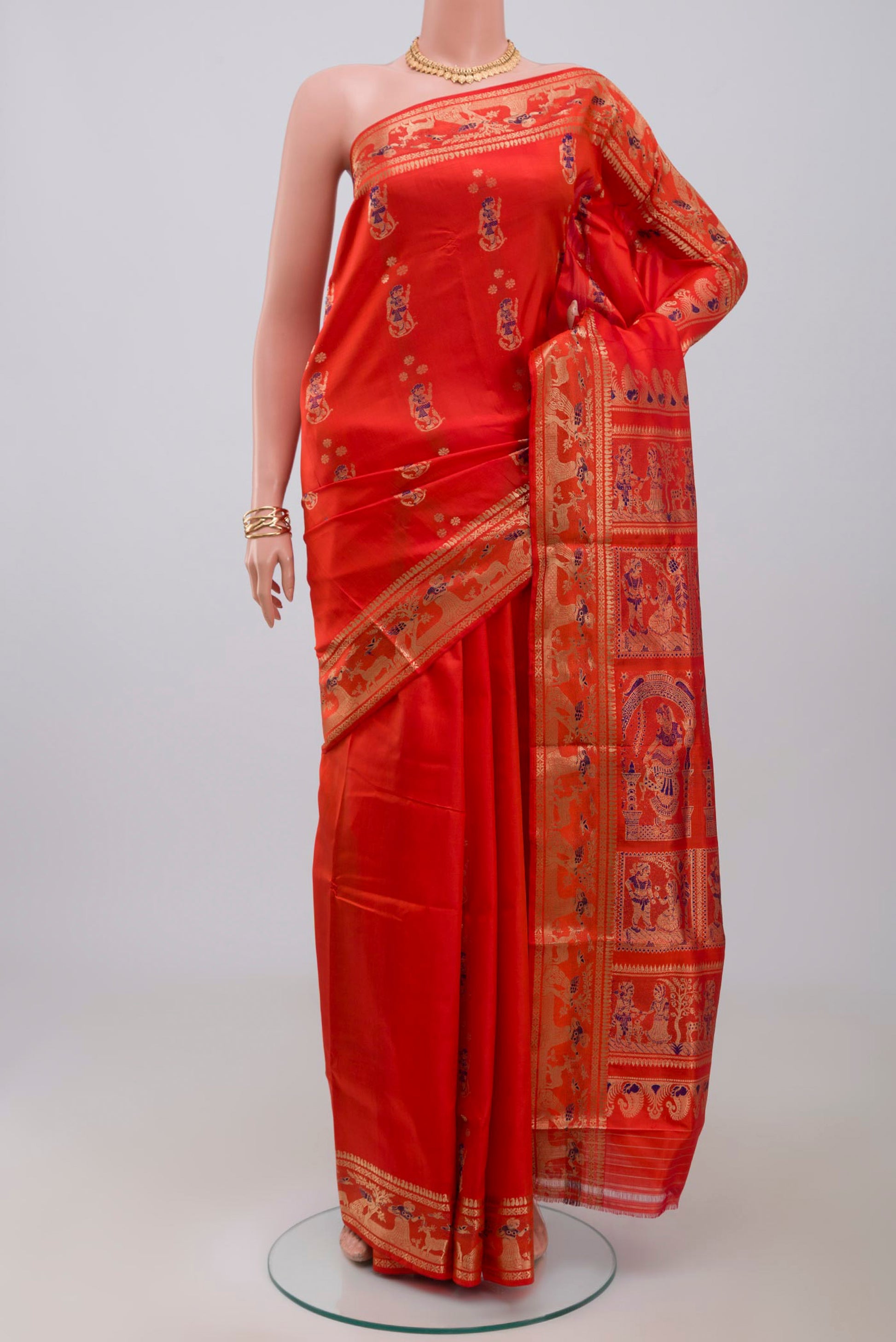 Orange Baluchari Silk Saree with Zari And Thread Butta on the body and Zari Border.  displayed on a mannequin