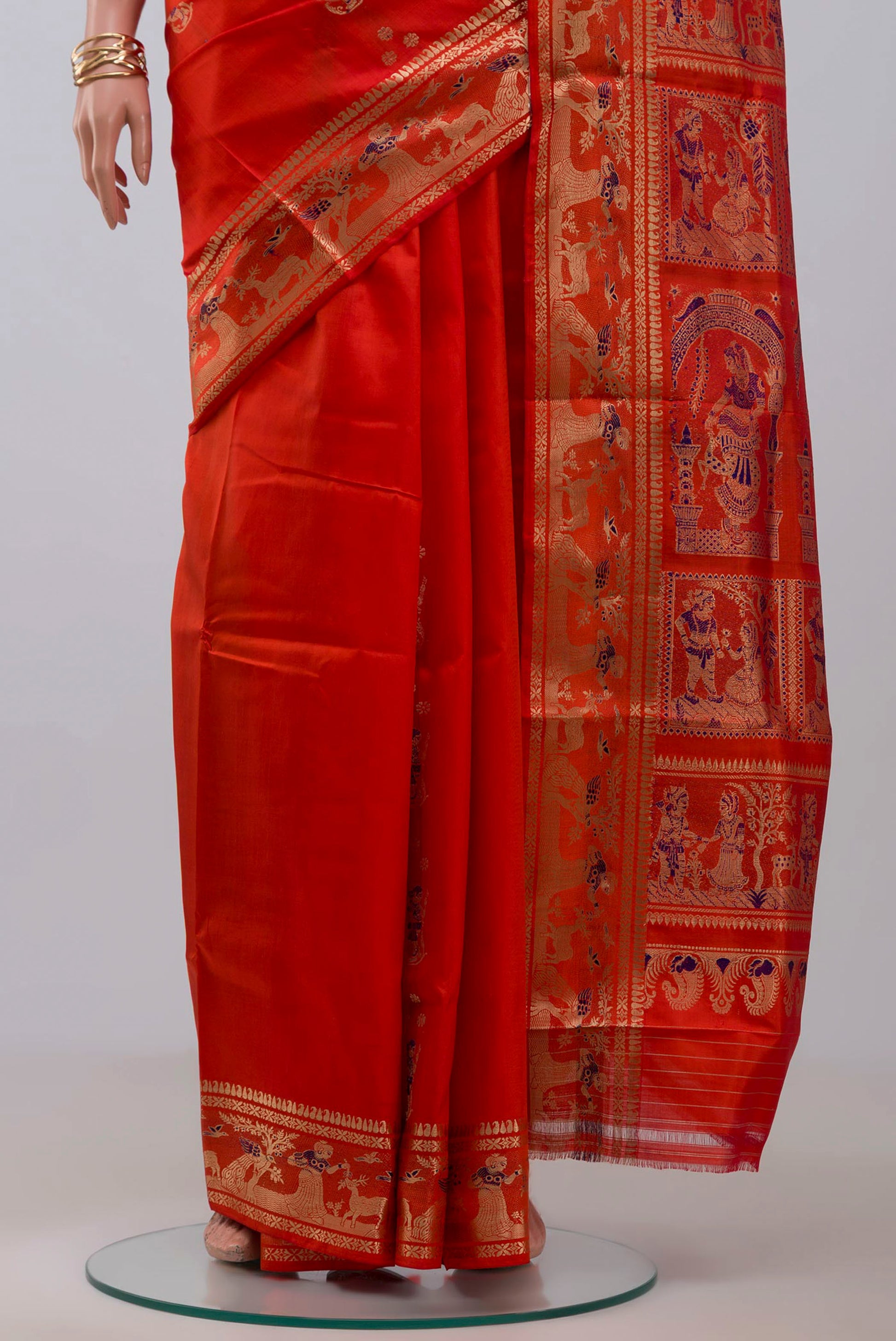 Pleats and pallu of Orange Baluchari Silk Saree with Zari And Thread Butta on the body and Zari Border. 