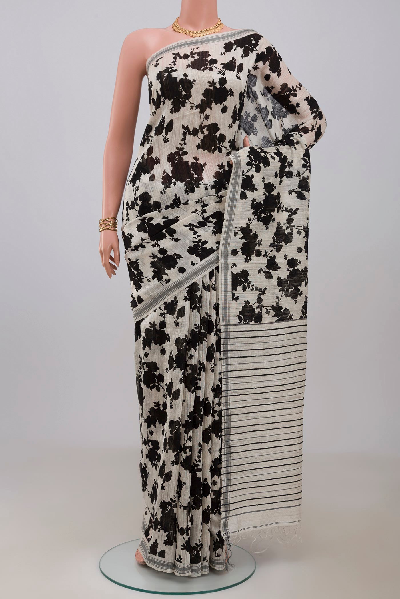 Cream Tussar Silk Saree with Floral Print on the body and Plain Border.  displayed on a mannequin