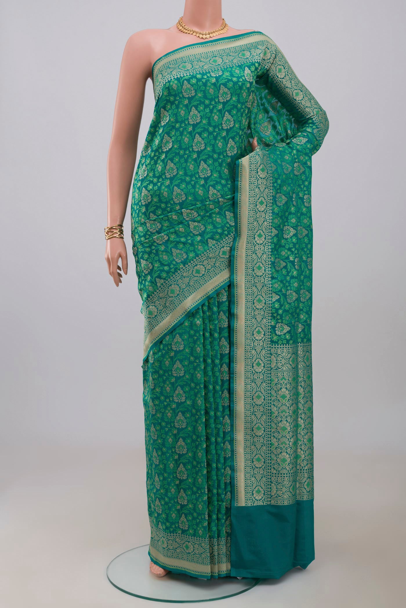 Green Banarasi Saree with Fancy on the body and Fancy Border.  displayed on a mannequin