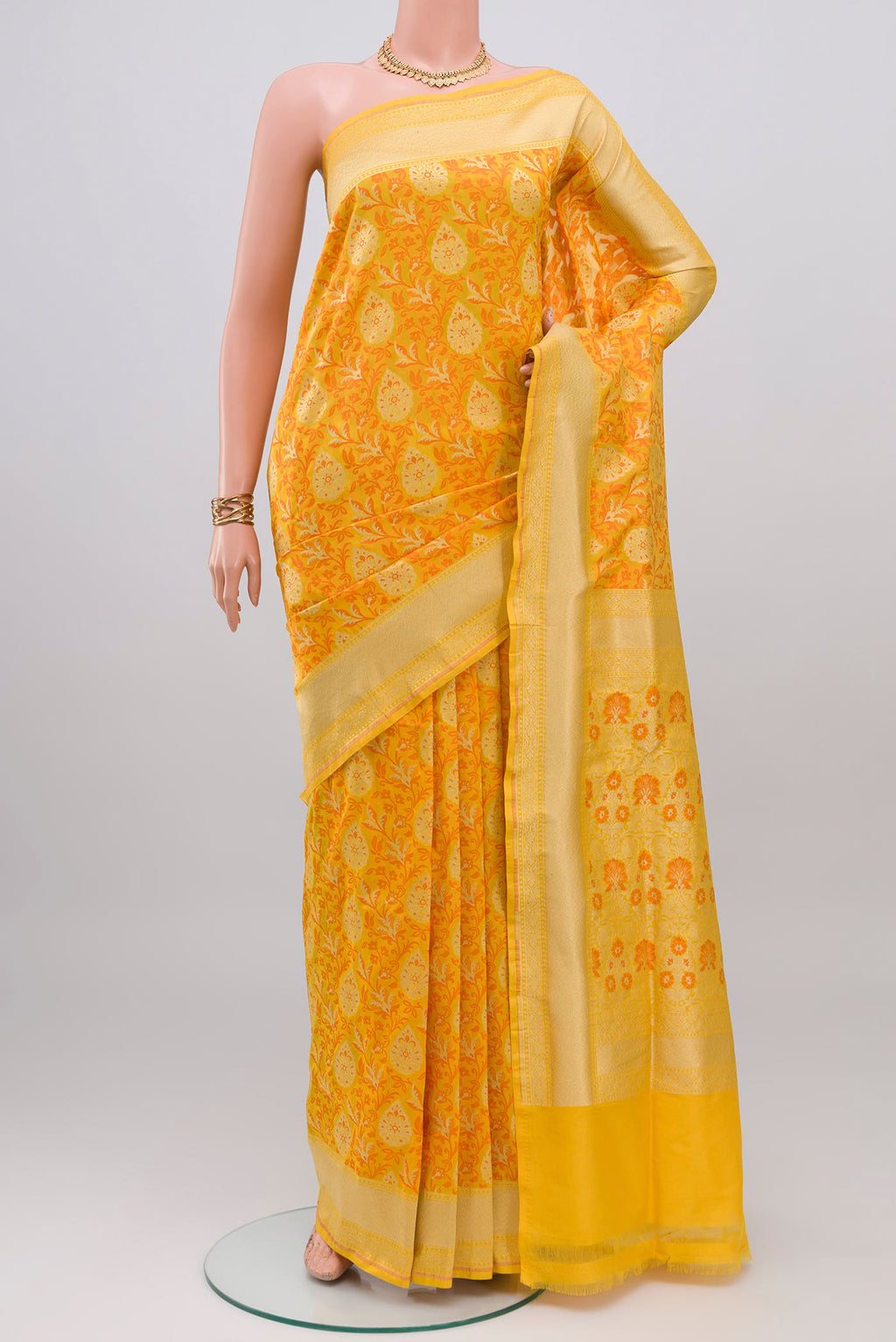 Yellow Banarasi Silk Saree with Zari And Thread Butta on the body and Zari Border.  displayed on a mannequin