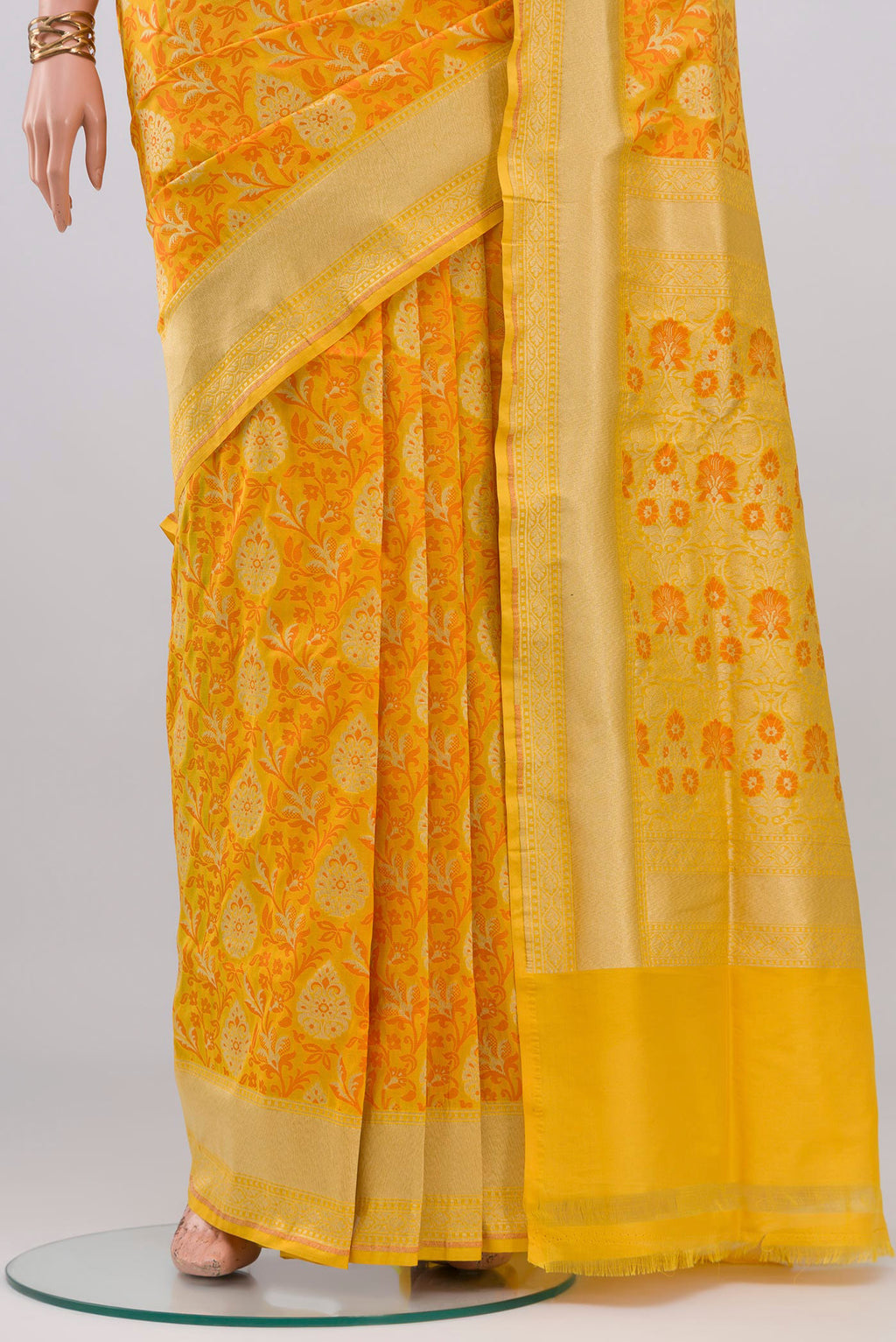 Pleats and pallu of Yellow Banarasi Silk Saree with Zari And Thread Butta on the body and Zari Border. 