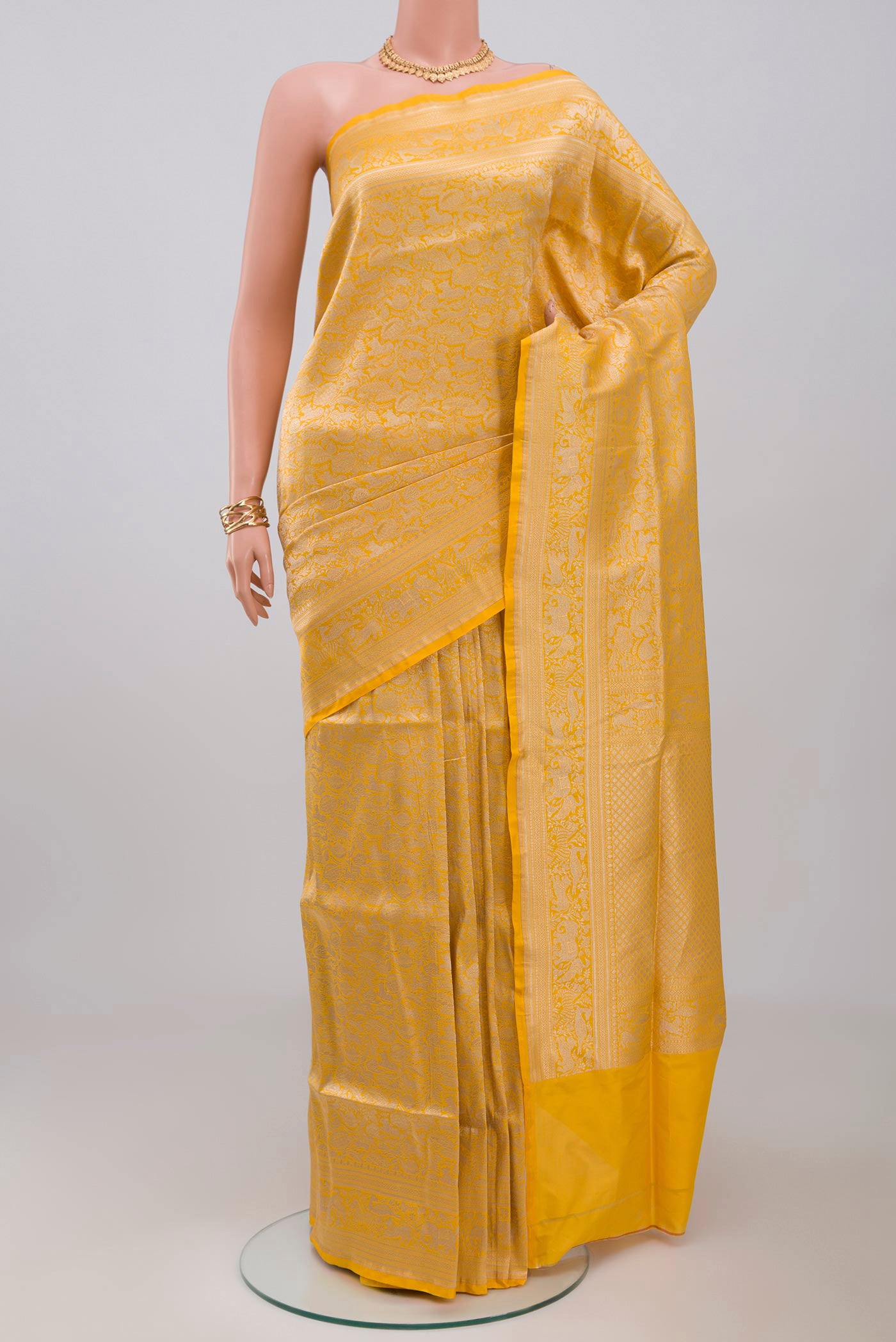 Yellow Banarasi Saree with Zari Brocade on the body and Fancy Border.  displayed on a mannequin