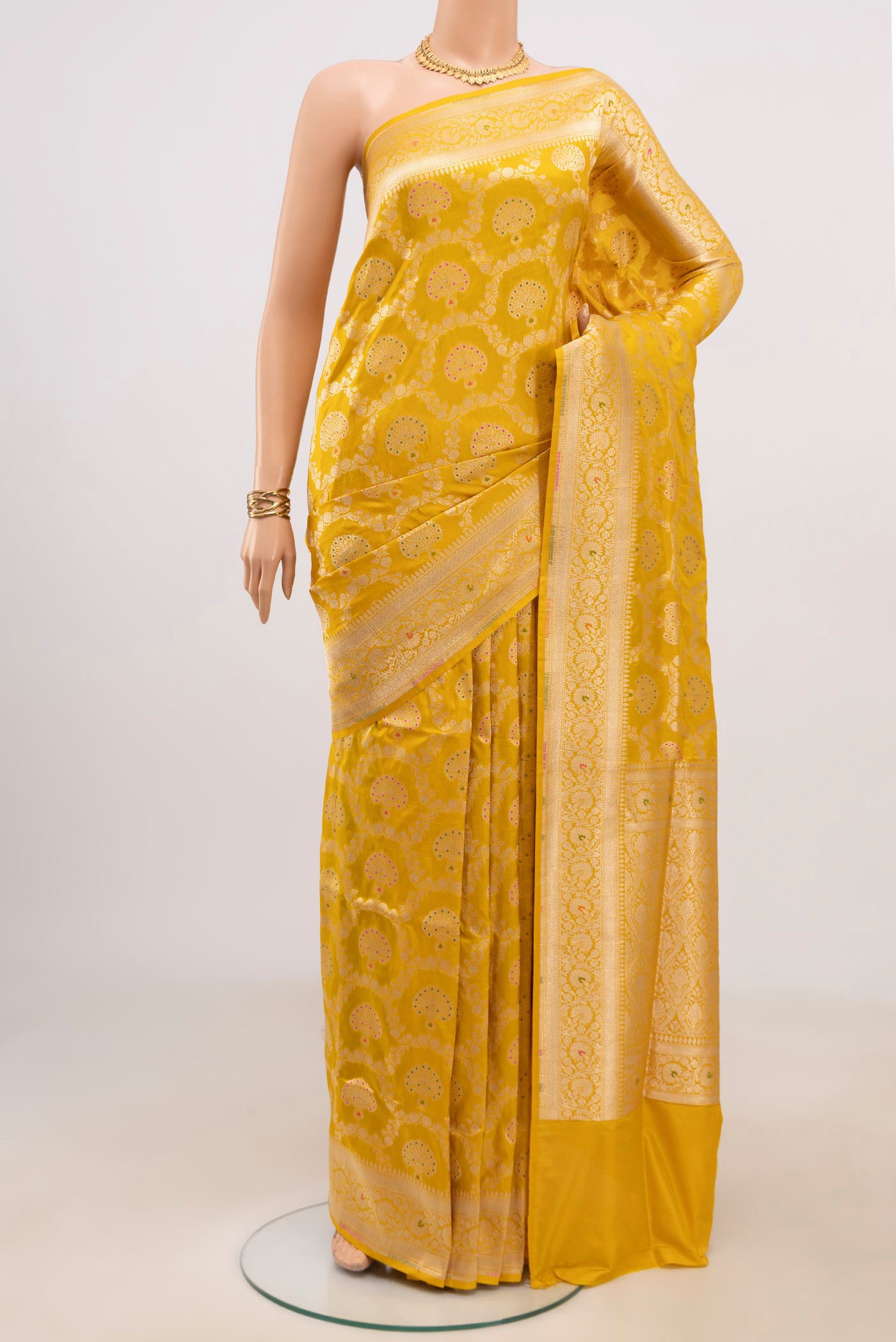 Yellow Banarasi Saree with Zari Brocade on the body and Fancy Border.  displayed on a mannequin