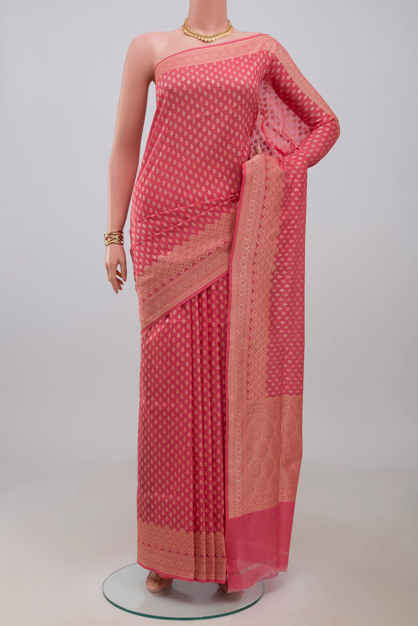 Coral Banarasi Silk Saree with Zari Butta on the body and Zari Border.  displayed on a mannequin