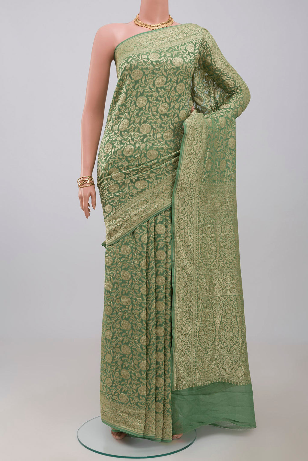 Green Georgette Saree with Fancy on the body and Zari Border.  displayed on a mannequin