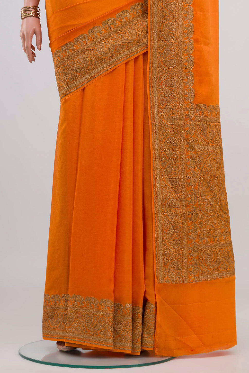 Pleats and pallu of Orange Banarasi Georgette Saree with Plain Body and Zari Border. 