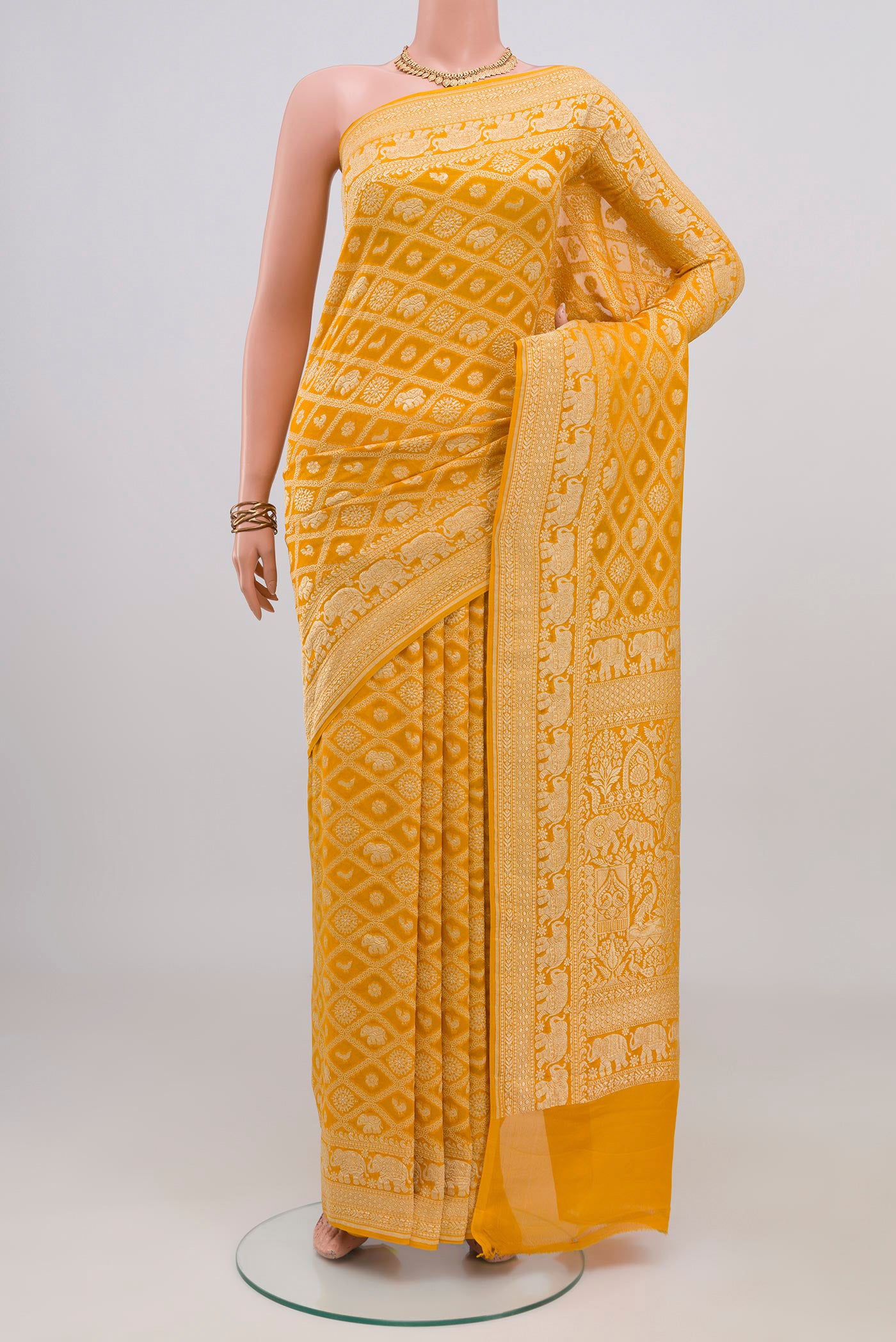 Yellow Banarasi Georgette Saree with Zari Brocade on the body and Zari Border.  displayed on a mannequin