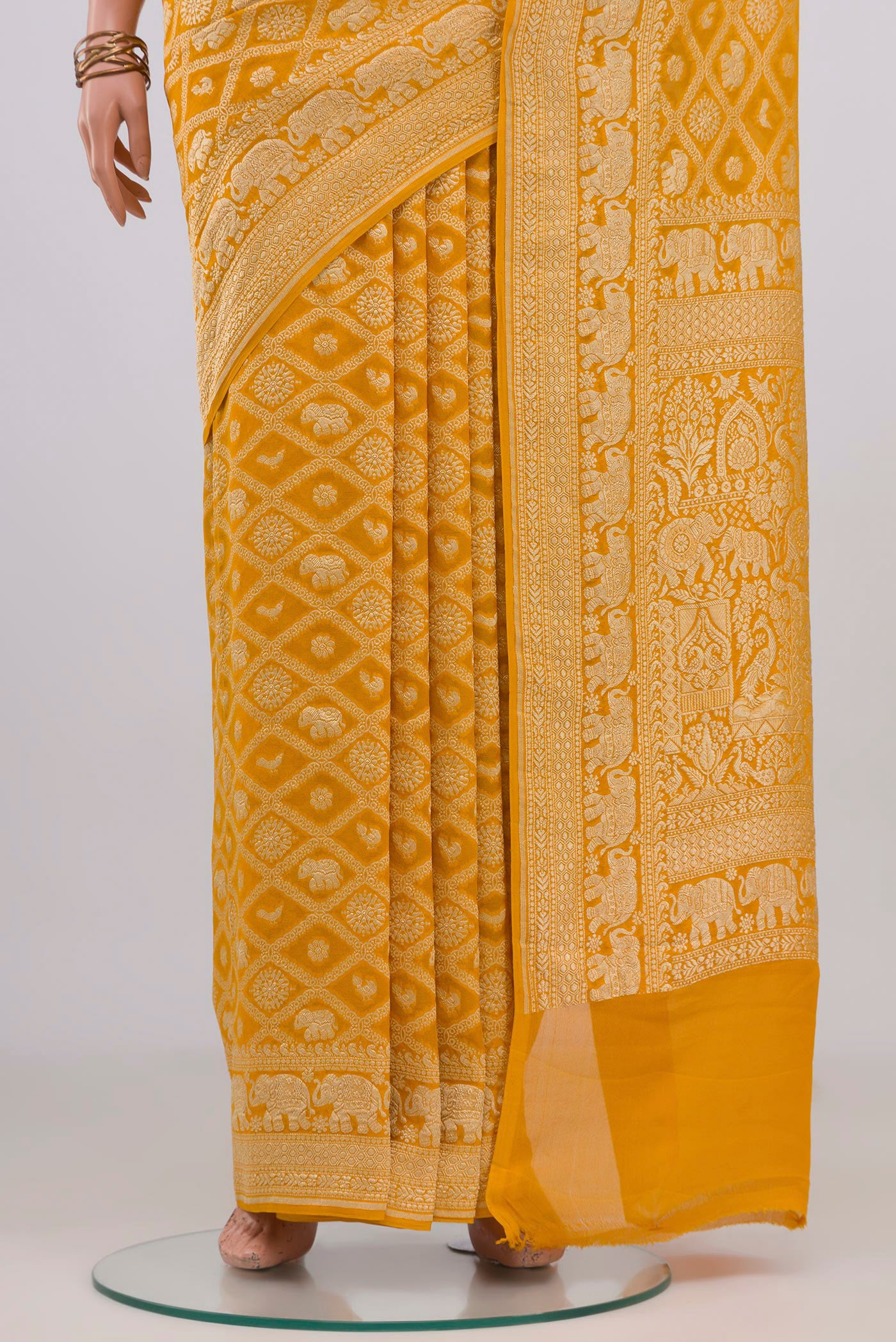 Pleats and pallu of Yellow Banarasi Georgette Saree with Zari Brocade on the body and Zari Border. 