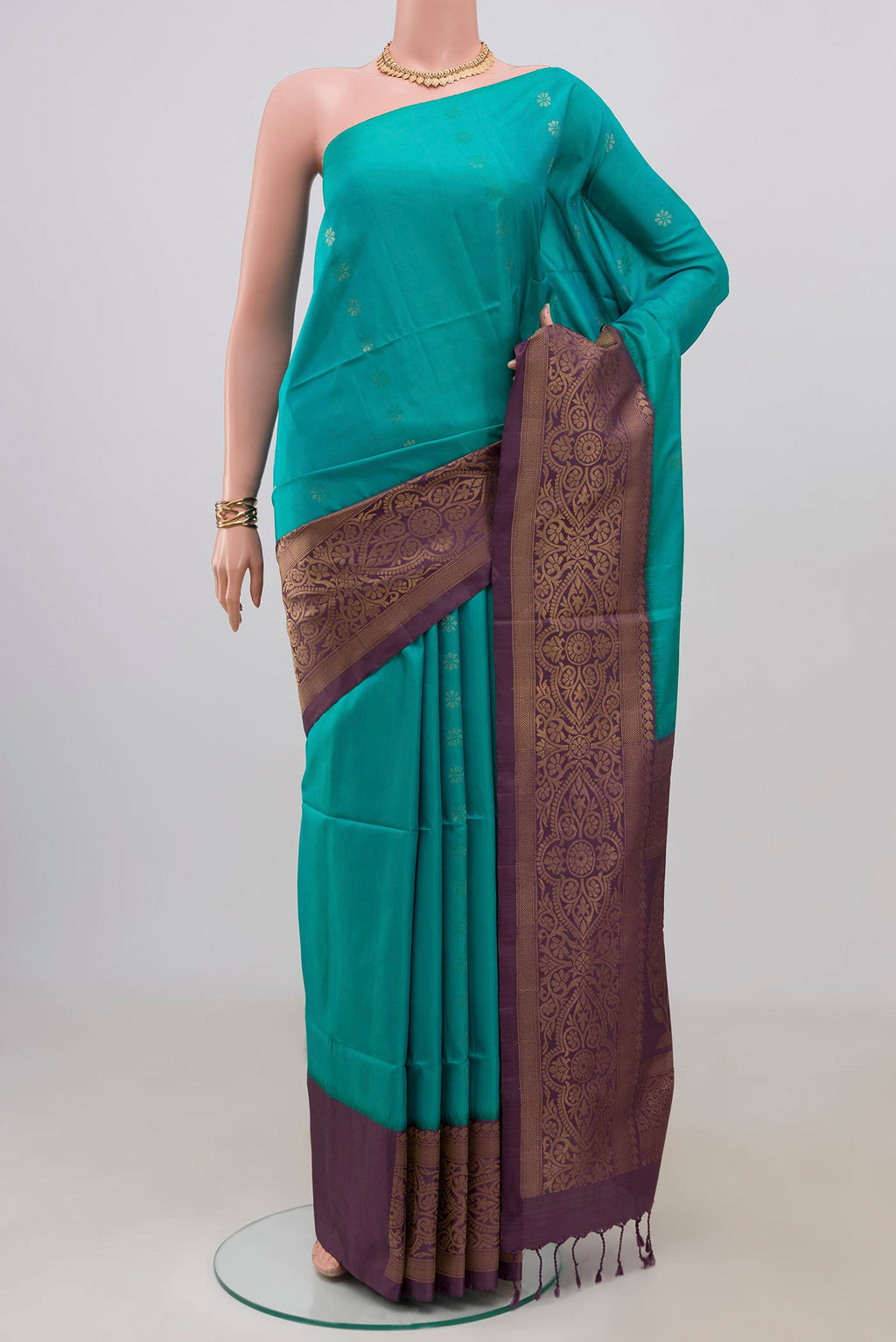Peacock Blue Soft Silk Saree with Zari Butta on the body and Fancy Border.  displayed on a mannequin