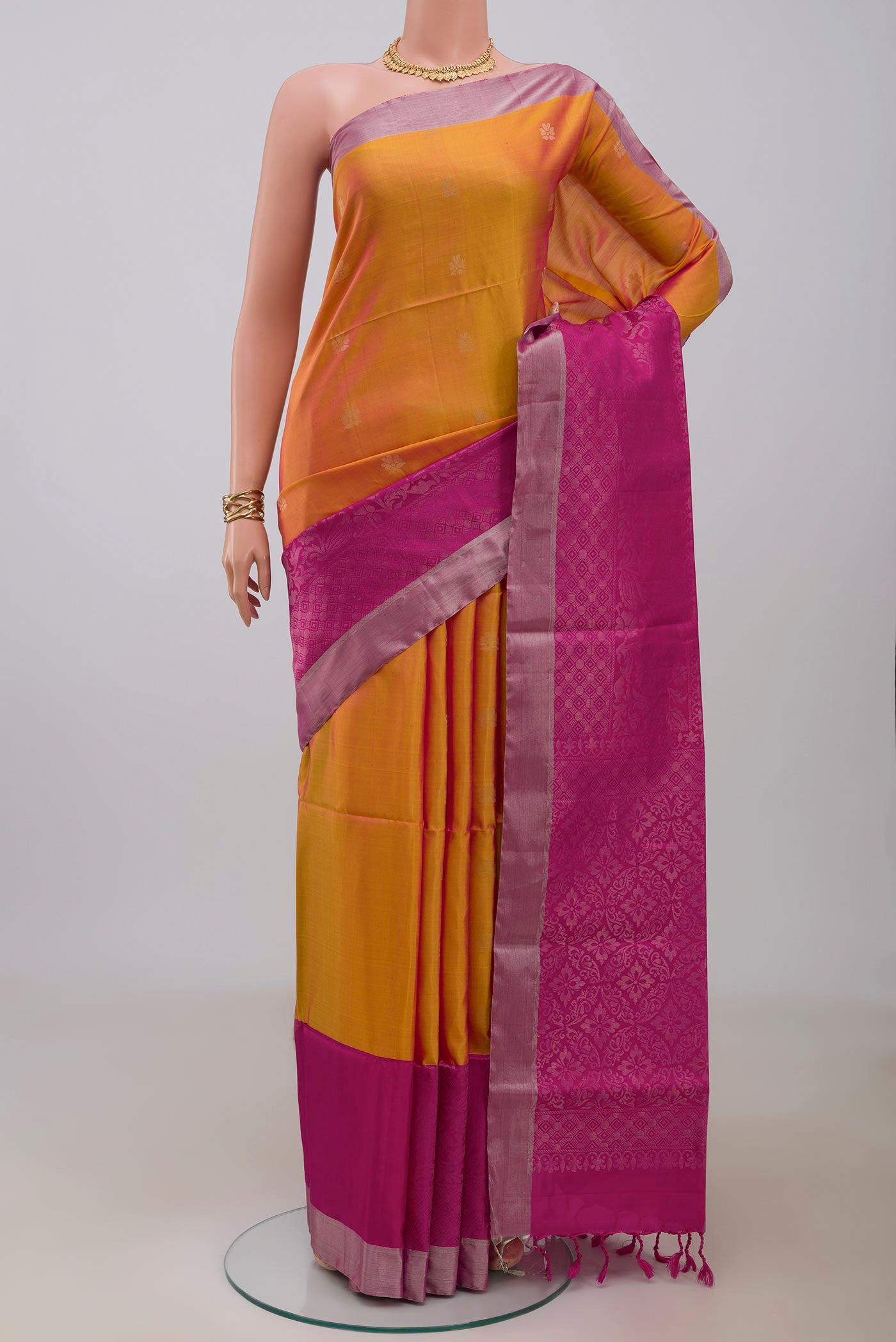 Yellow Soft Silk Saree with Zari Butta on the body and Fancy Border.  displayed on a mannequin