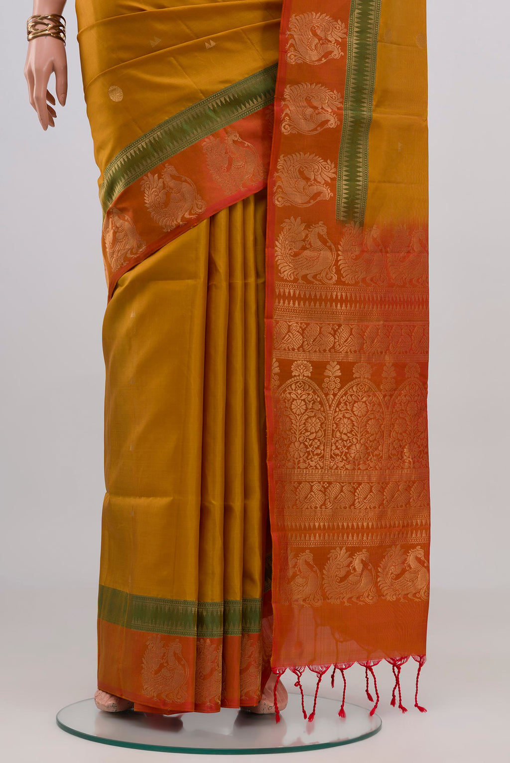 Pleats and pallu of Mustard Soft Silk Saree with Zari Butta on the body and Fancy Border. 