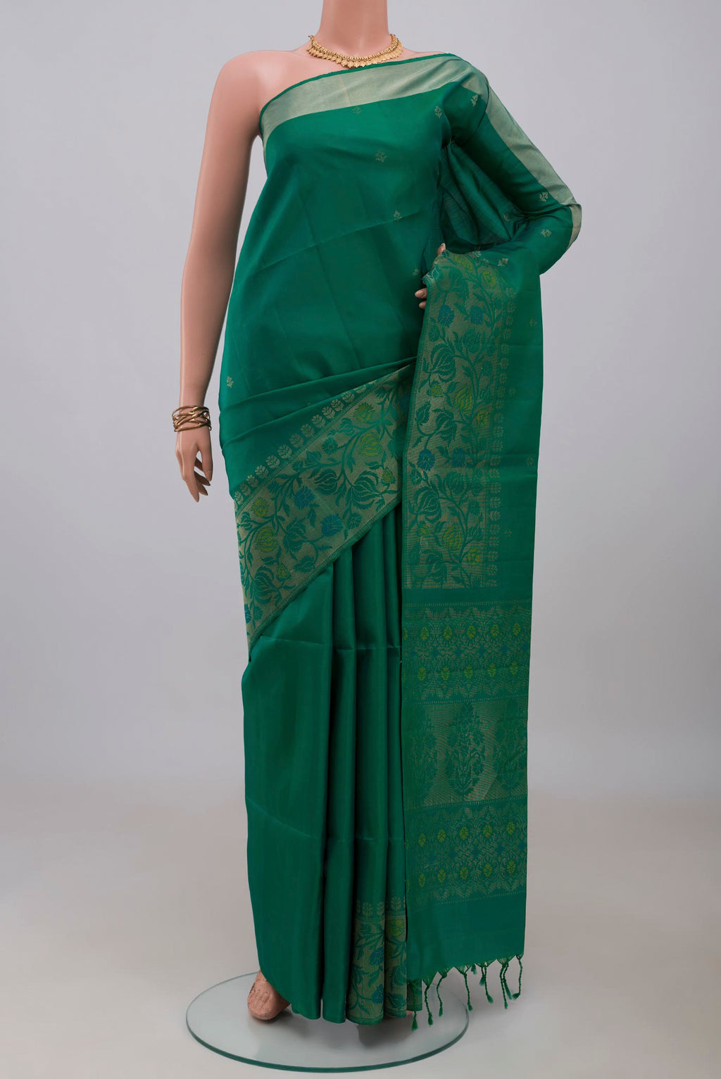 Green Soft Silk Saree with Zari Butta on the body and Zari Border.  displayed on a mannequin