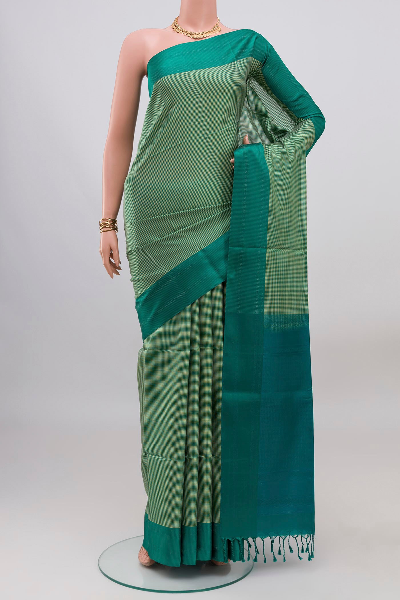 Sage Green Soft Silk Saree with Checked design on the body and Plain Border.  displayed on a mannequin
