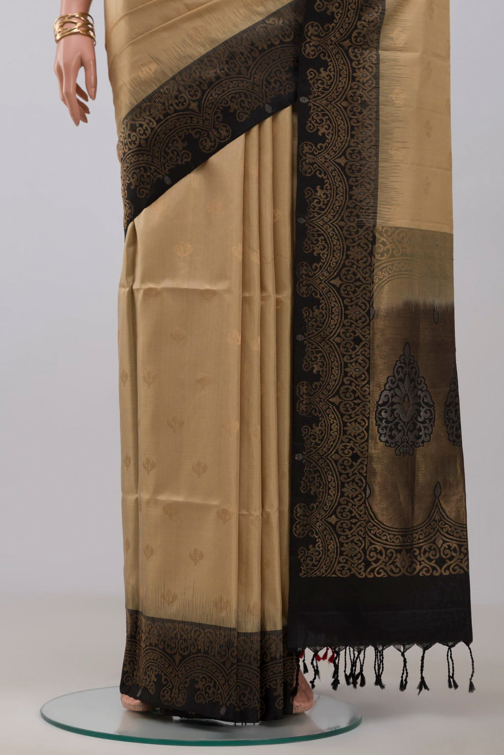 Pleats and pallu of Beige Soft Silk Saree with Zari Butta on the body and Fancy Border. 