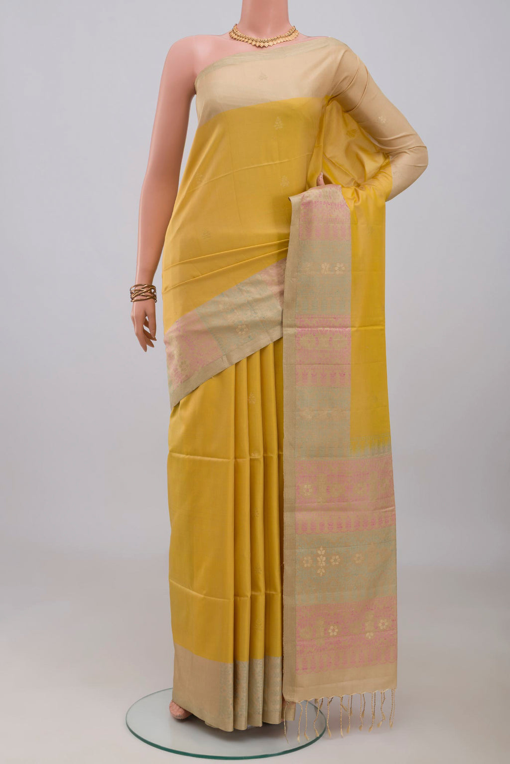 Yellow Soft Silk Saree with Zari Butta on the body and Zari Border.  displayed on a mannequin