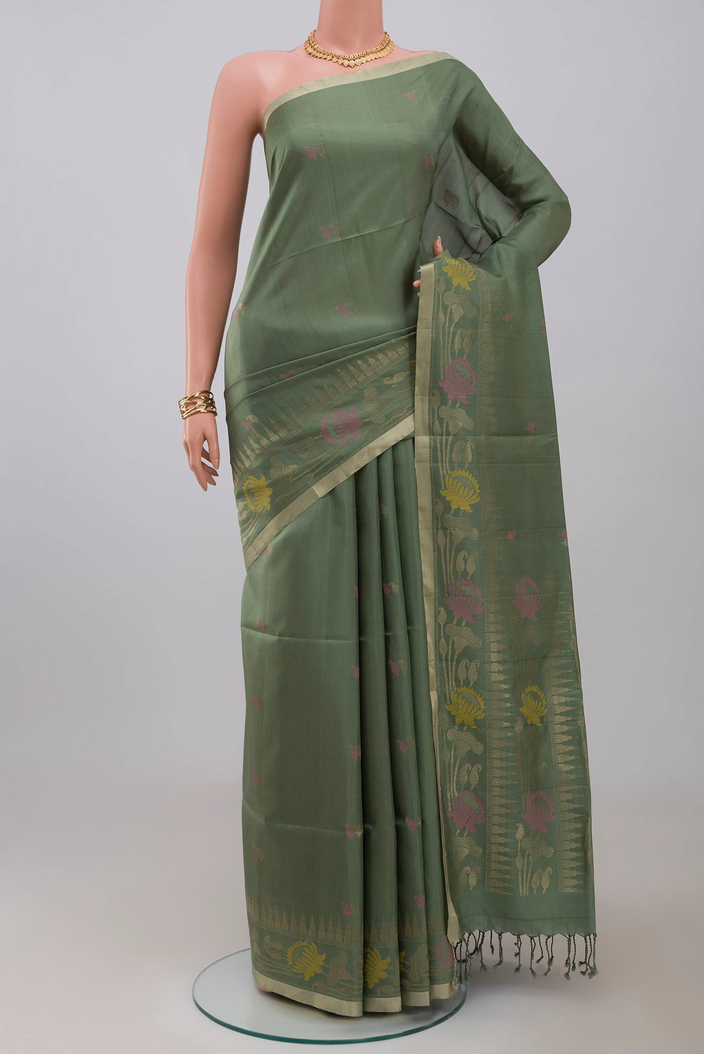 Green Soft Silk Saree with Zari And Thread Butta on the body and Fancy Border.  displayed on a mannequin