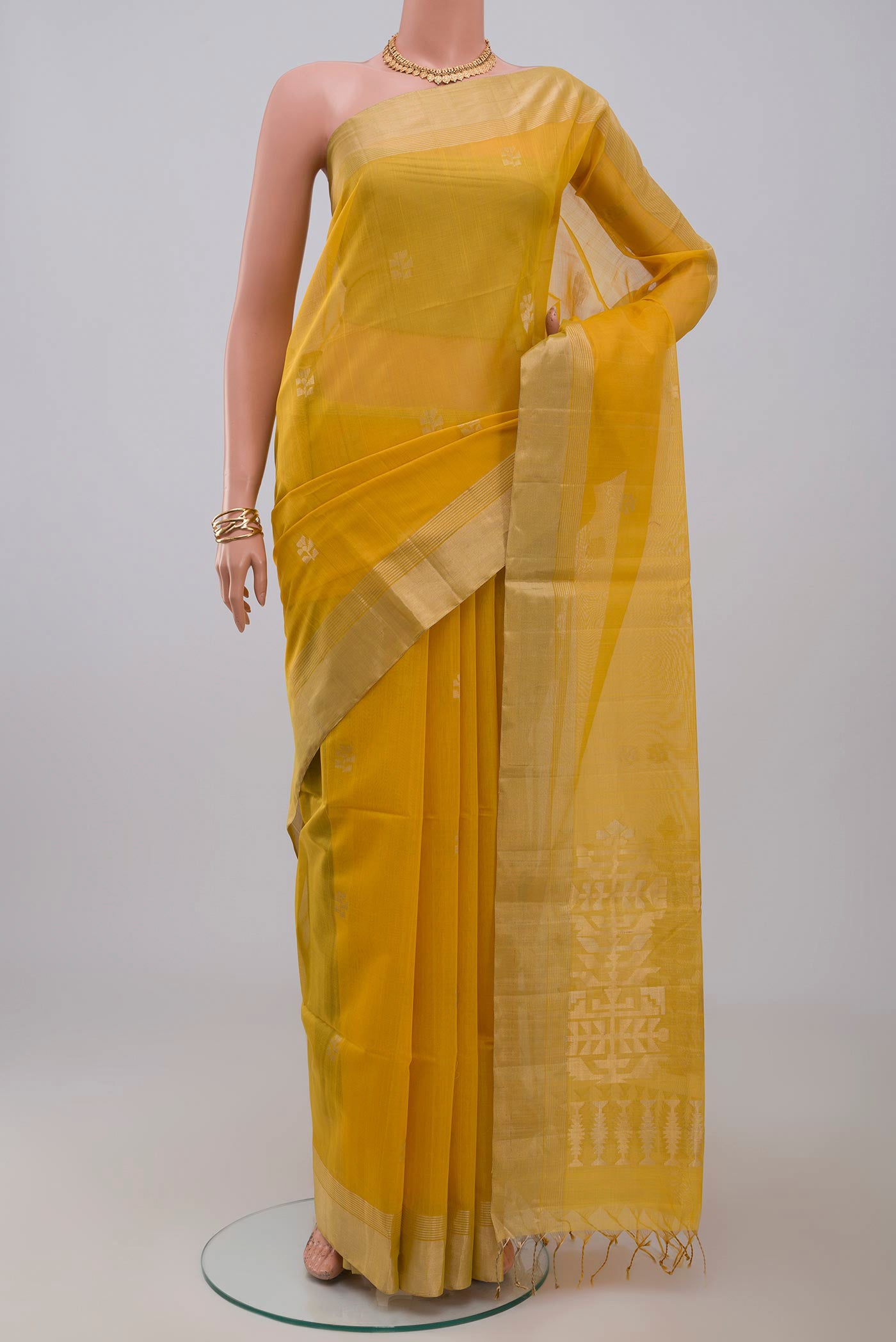 Yellow Silk Cotton Saree with Zari Butta on the body and Zari Border.  displayed on a mannequin
