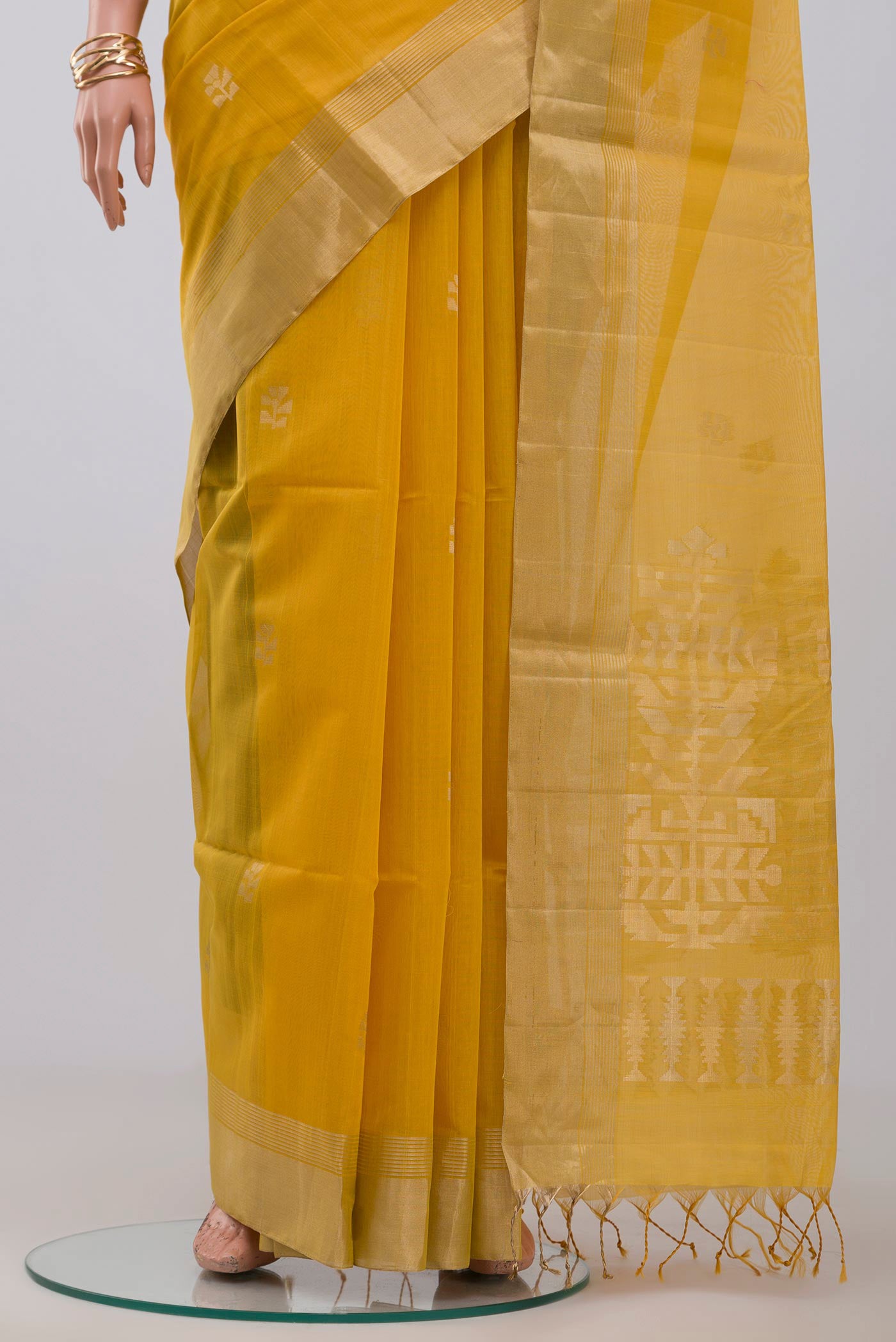 Pleats and pallu of Yellow Silk Cotton Saree with Zari Butta on the body and Zari Border. 