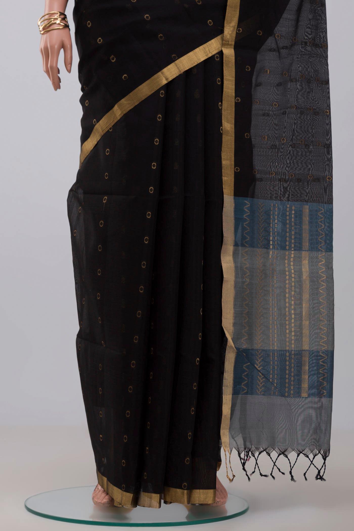Pleats and pallu of Black Silk Cotton Saree with Zari Butta on the body and Thin Zari Line. 