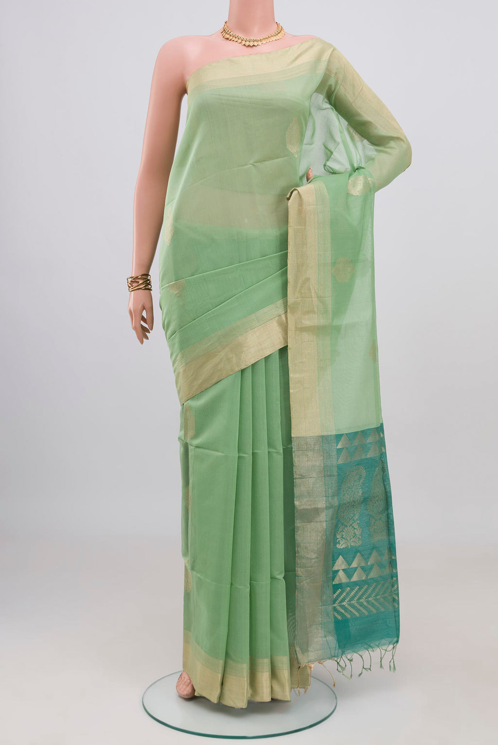 Pista Green Silk Cotton Saree with Zari Butta on the body and Zari Border.  displayed on a mannequin