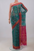 Green Silk Cotton Saree with Ikat Print on the body and Zari Border.  displayed on a mannequin
