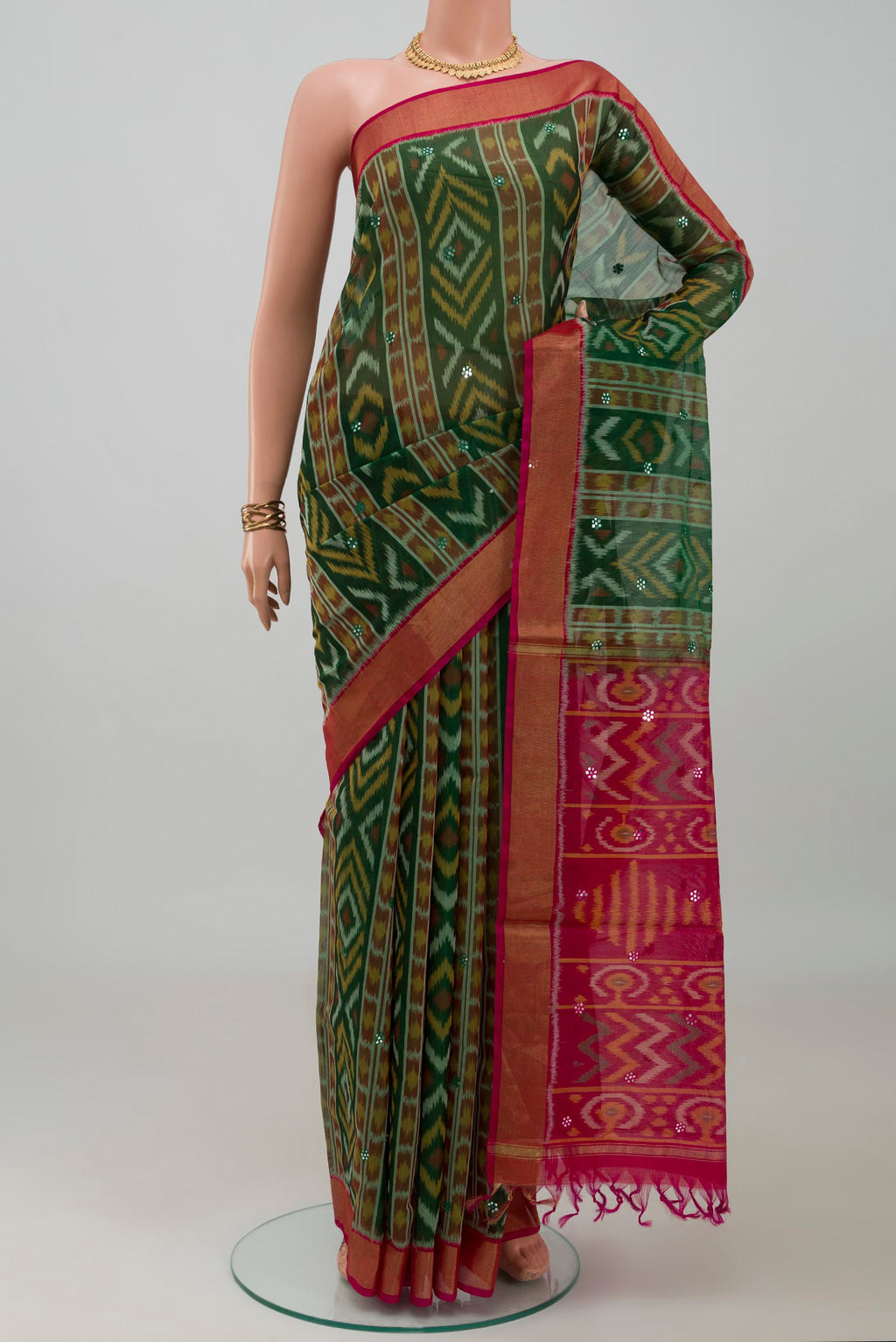 Green Silk Cotton Saree with Ikat design on the body and Zari Border.  displayed on a mannequin