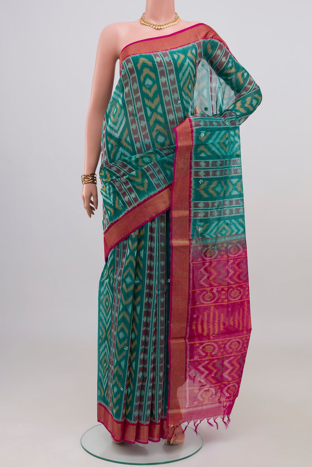 Green Silk Cotton Saree with Ikat design on the body and Zari Border.  displayed on a mannequin